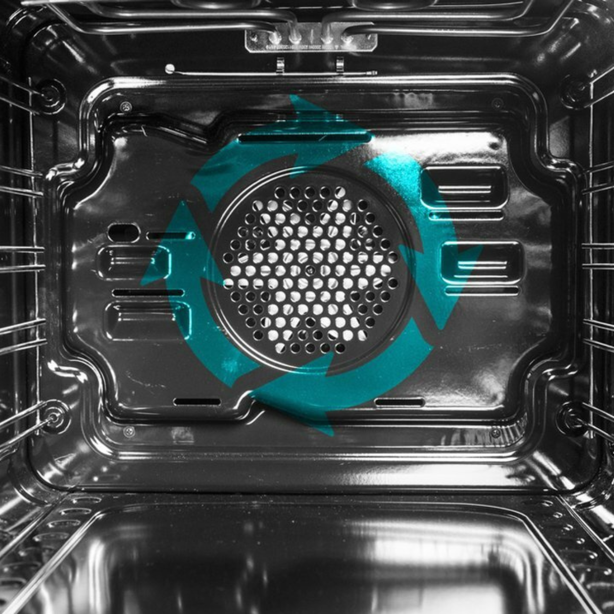 Inside of an oven with a teal recycling symbol on the back wall.