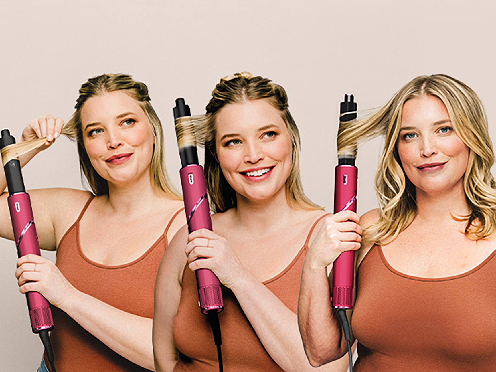 Trzy kobiety stylizują włosy różową lokówką, trzymając wałek do góry.