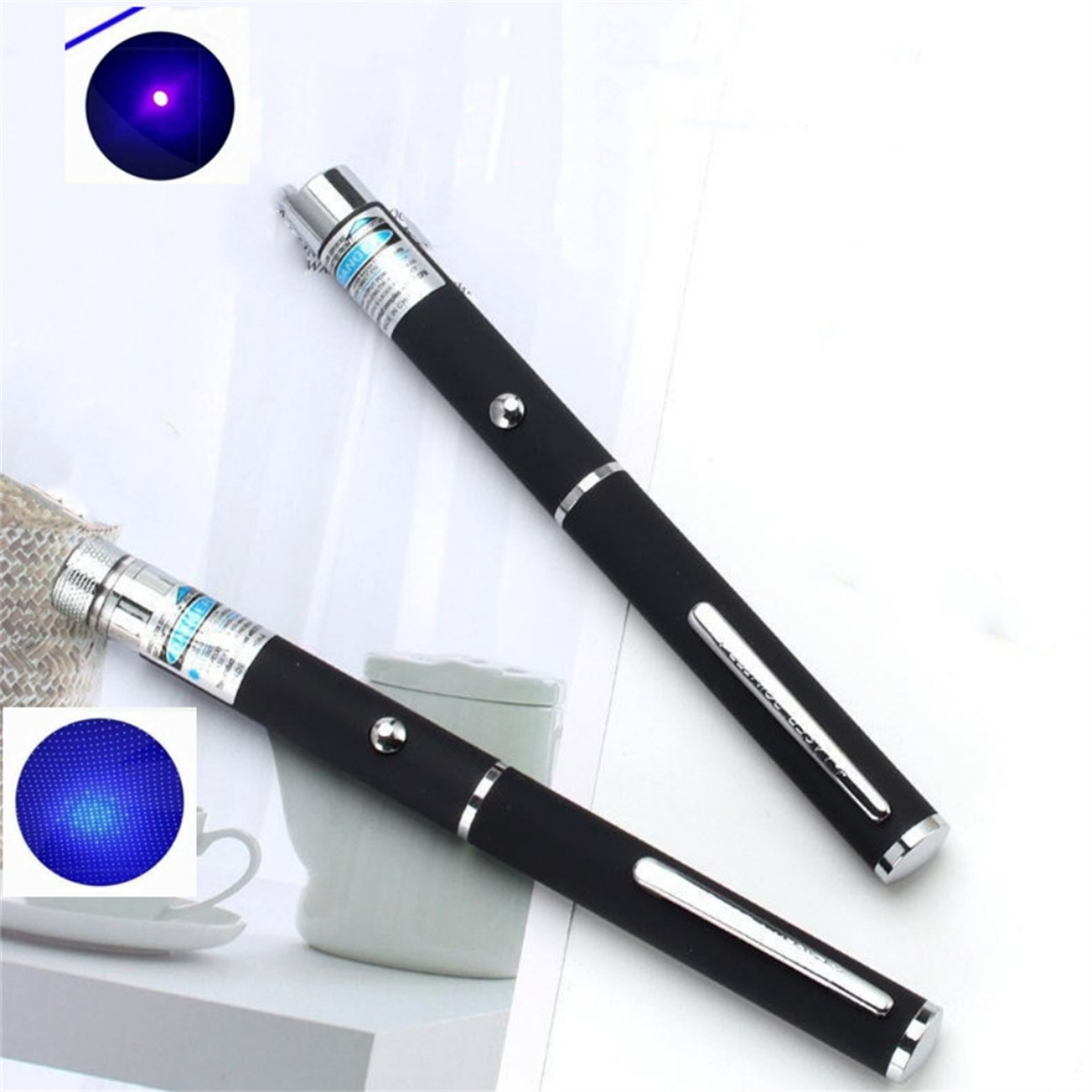 Zwei schwarze Laserpointer, mit blauem Lichteffekt, auf weißer Oberfläche.