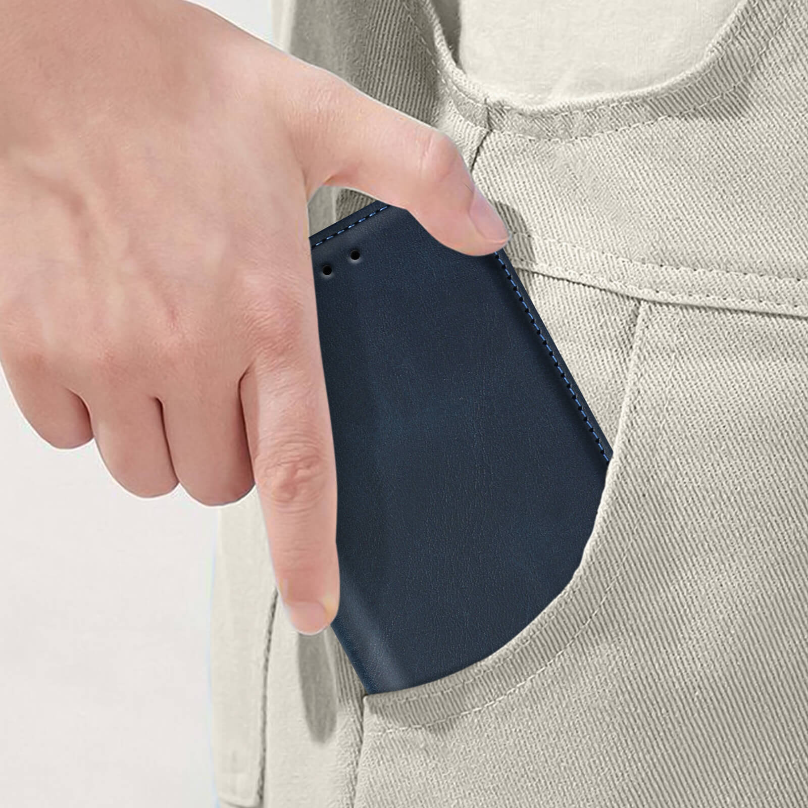 Una mano che inserisce una custodia blu in una tasca beige.