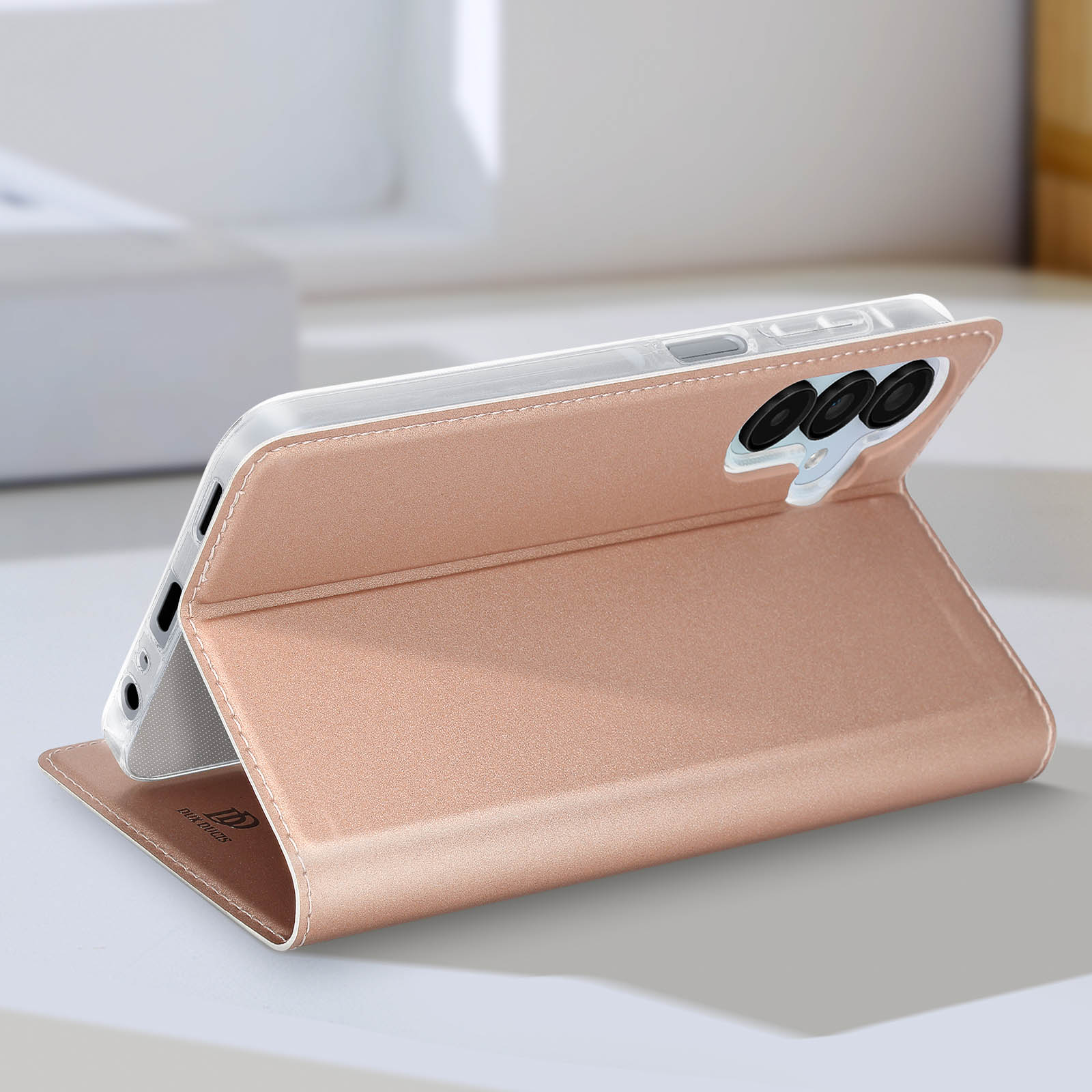 Eine roségoldene Handyhülle mit einem Telefon darin, geöffnet und aufgestellt.