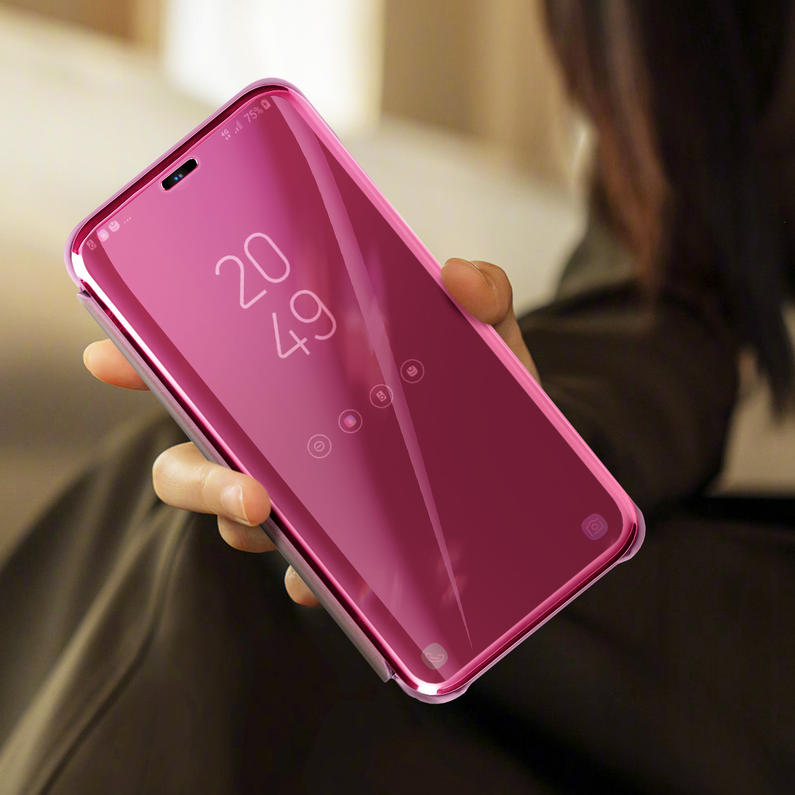 Una custodia rosa per telefono con parte anteriore a specchio, tenuta in mano. Lo schermo mostra l'ora.