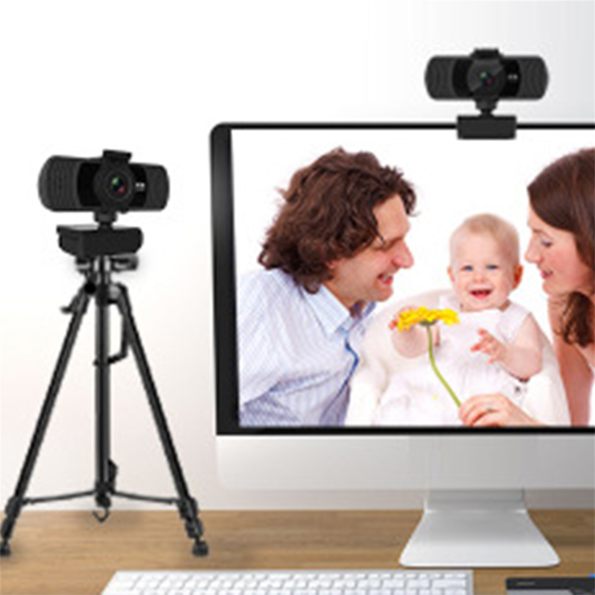 Webcams auf einem Schreibtisch, plus ein Monitor mit einer Familie. Tastatur im Vordergrund.