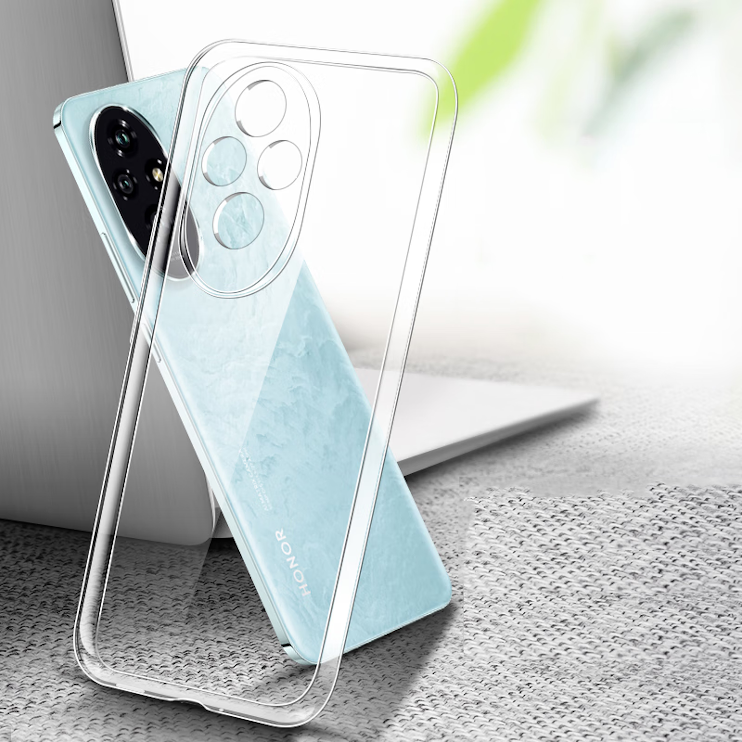 Eine transparente Handyhülle über einem blau-grünen Telefon. Das Telefon liegt auf einem Laptop, der Hintergrund ist unscharf.