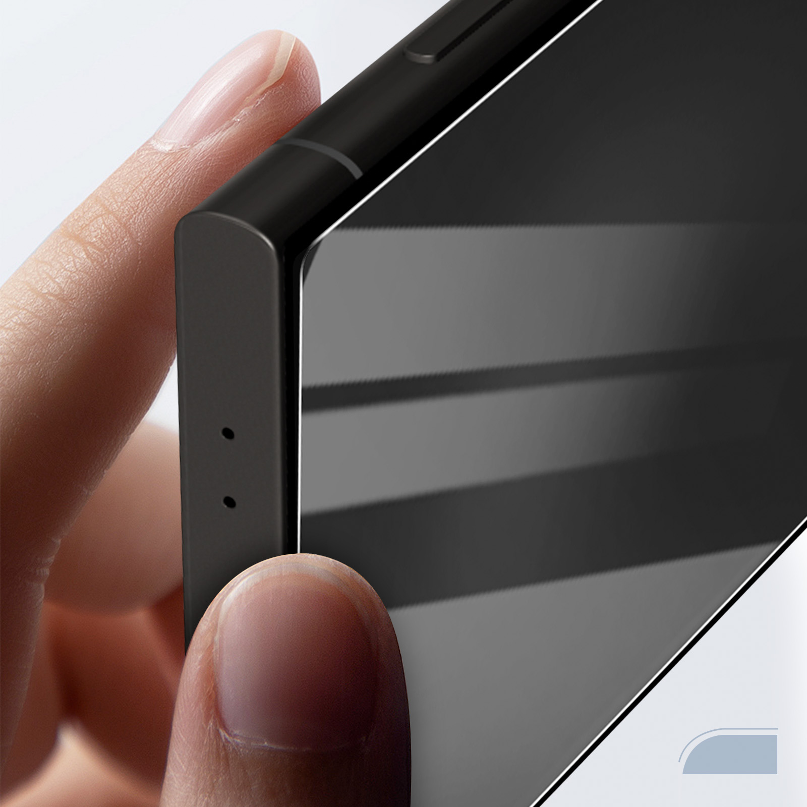 Zbliżenie dłoni trzymającej czarny smartfon. Palce dotykają krawędzi telefonu. Ekran odbija światło.