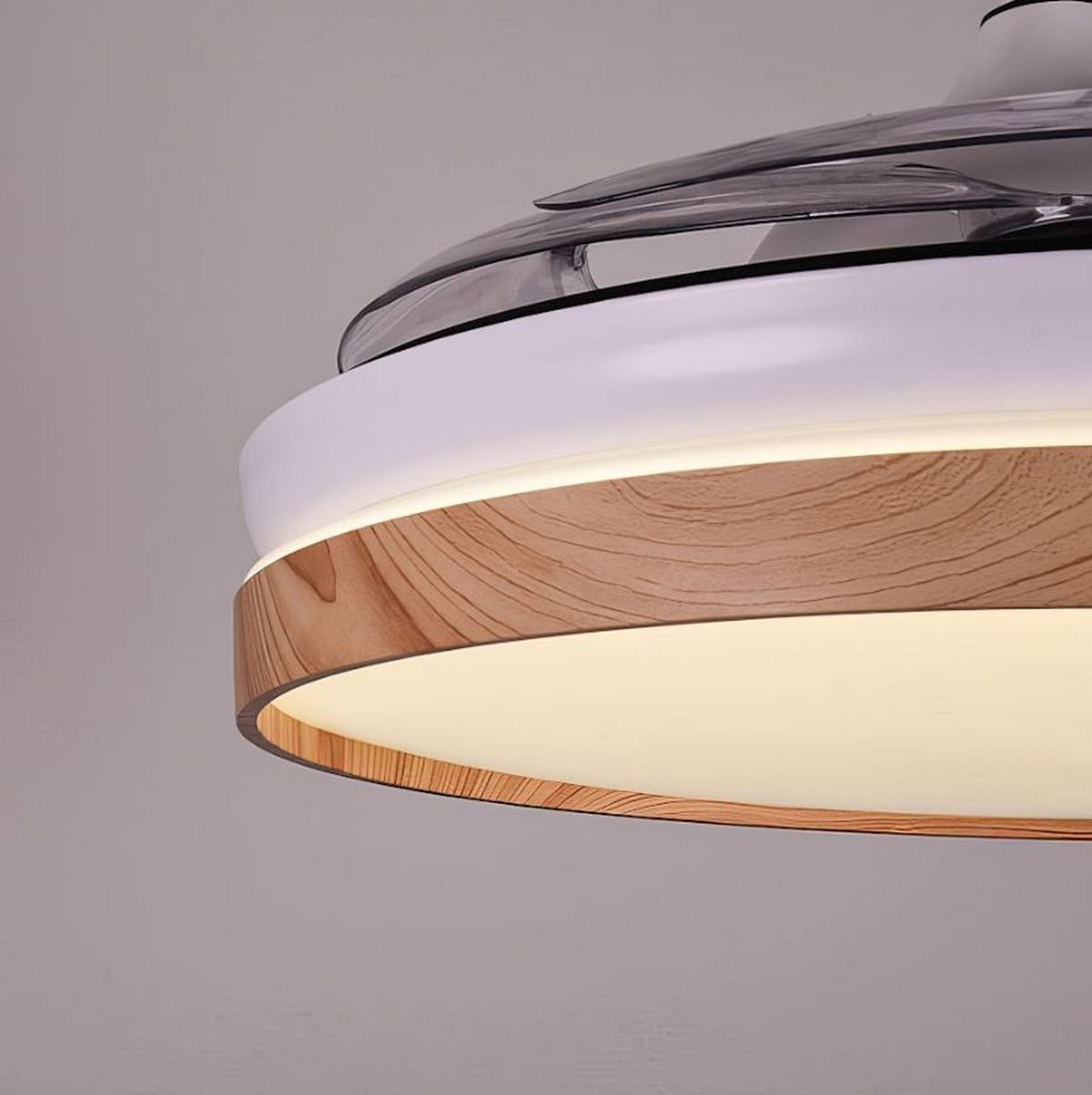 Ventilador de techo con diseño de madera y blanco, y una luz. Está encendido.