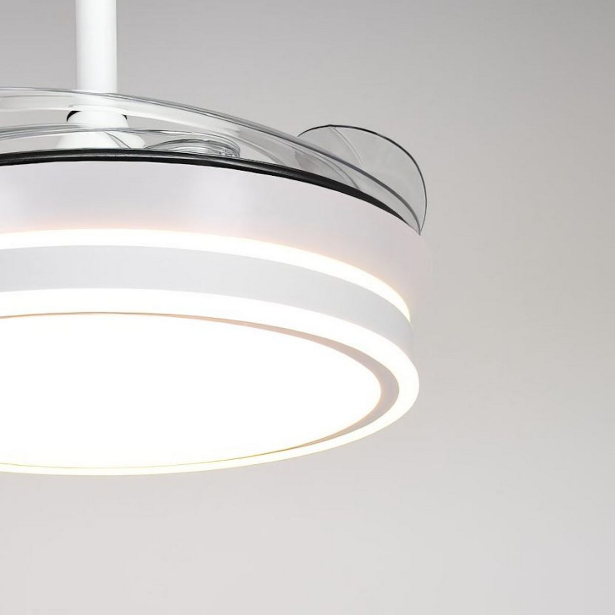Primer plano de un ventilador de techo blanco con luces integradas. Cuelga de un techo blanco.