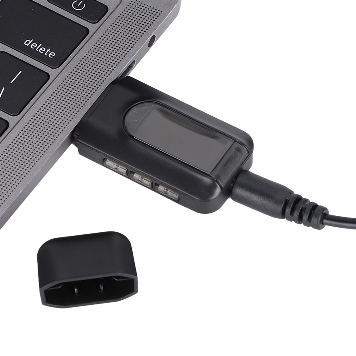USB-C-Adapter an einen Laptop angeschlossen. Schwarzer Adapter mit drei USB-Anschlüssen und Display.