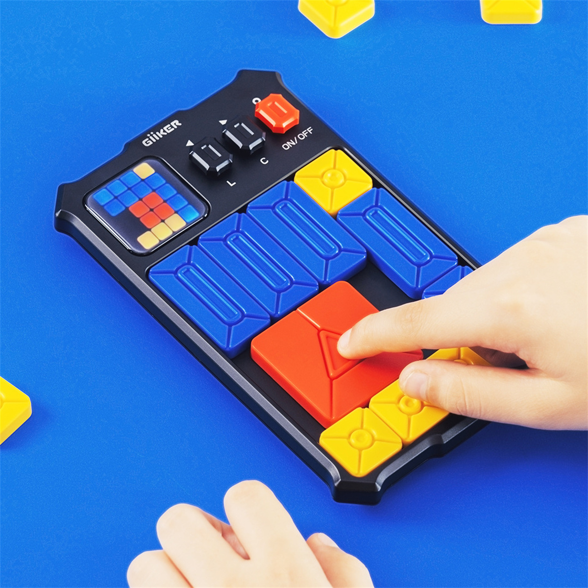 Eine Hand berührt ein rotes Puzzleteil auf einem schwarzen Spielbrett. Blaue, gelbe und rote Teile sind sichtbar. Der Hintergrund ist blau.