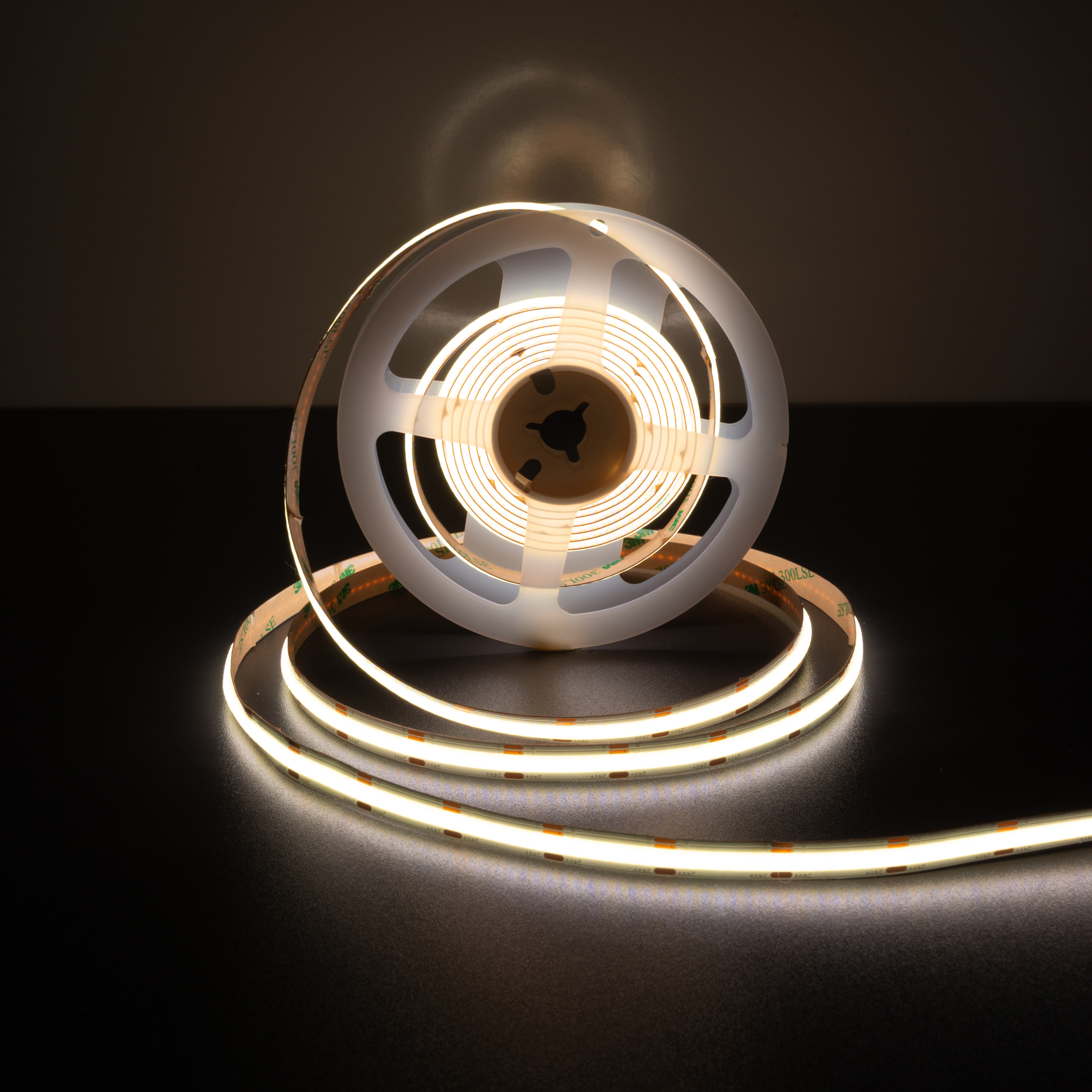 Eine Rolle LED-Streifen. Die Lichter sind weiß und gewickelt, mit dunklem Hintergrund.