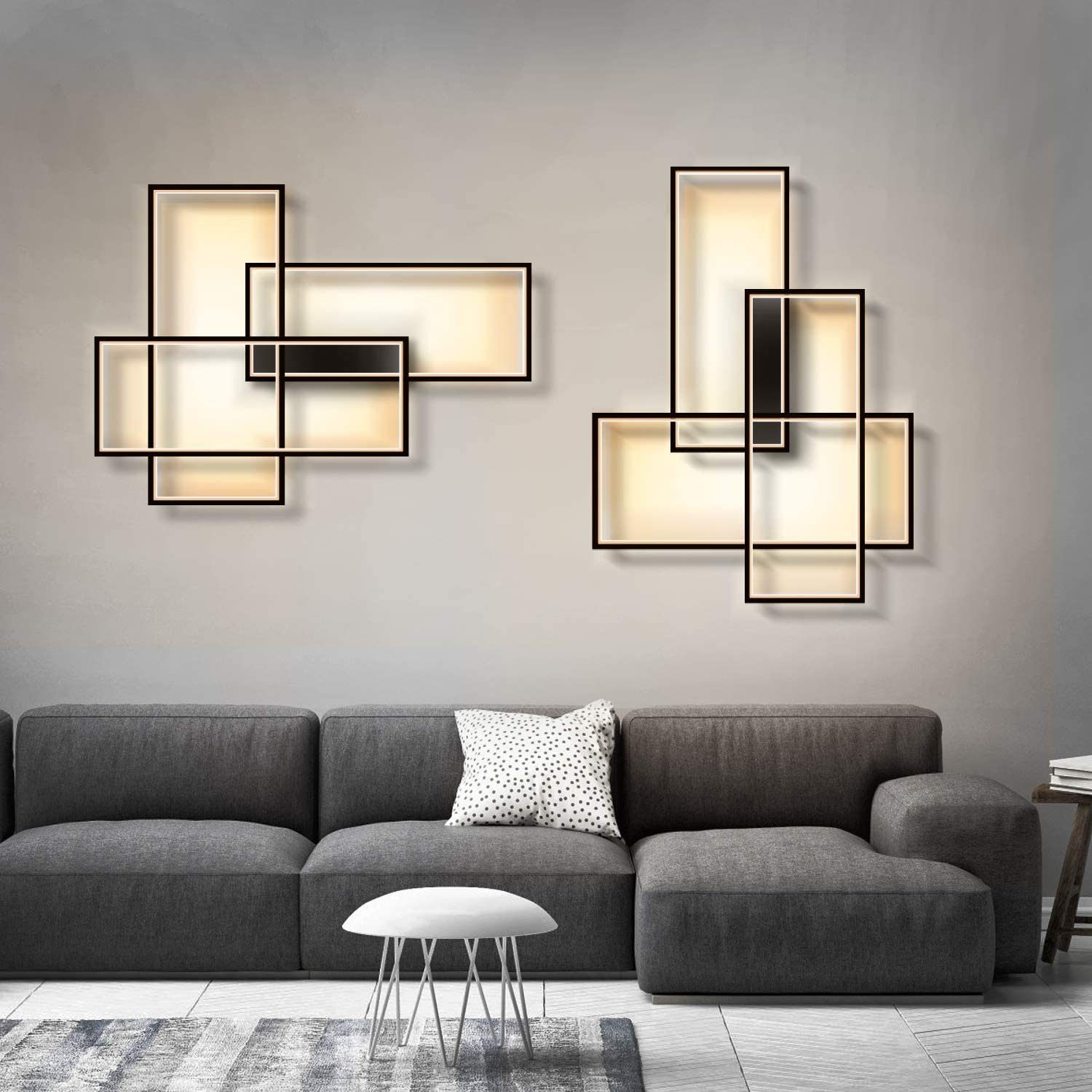 Nowoczesne lampy ścienne na szarej ścianie, z szarą sofą poniżej.