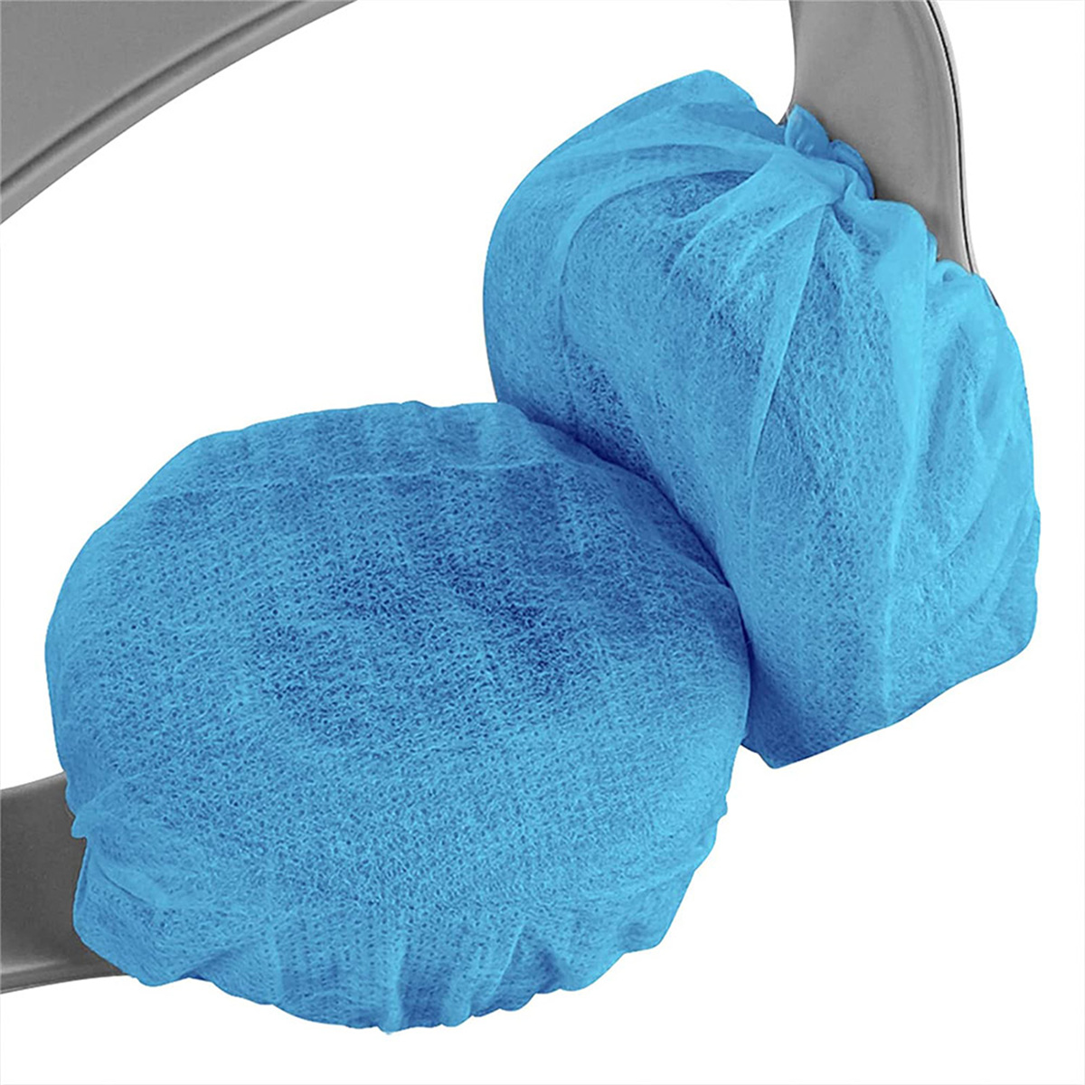 Zwei blaue OP-Hauben, auf einer Oberfläche platziert.