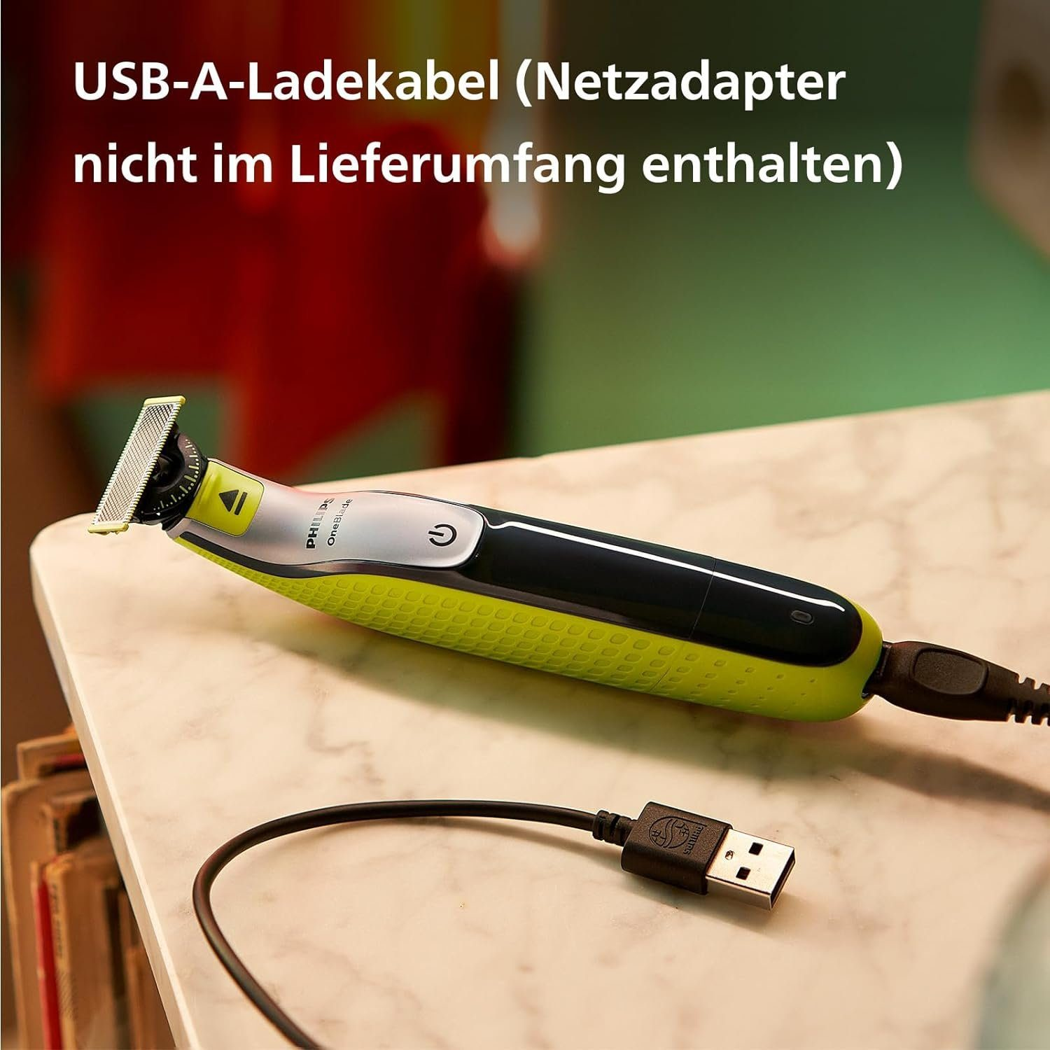 Grüner und gelber Elektrorasierer, der an ein USB-Kabel angeschlossen ist. Der Text 'USB-A-Ladekabel' ist sichtbar.