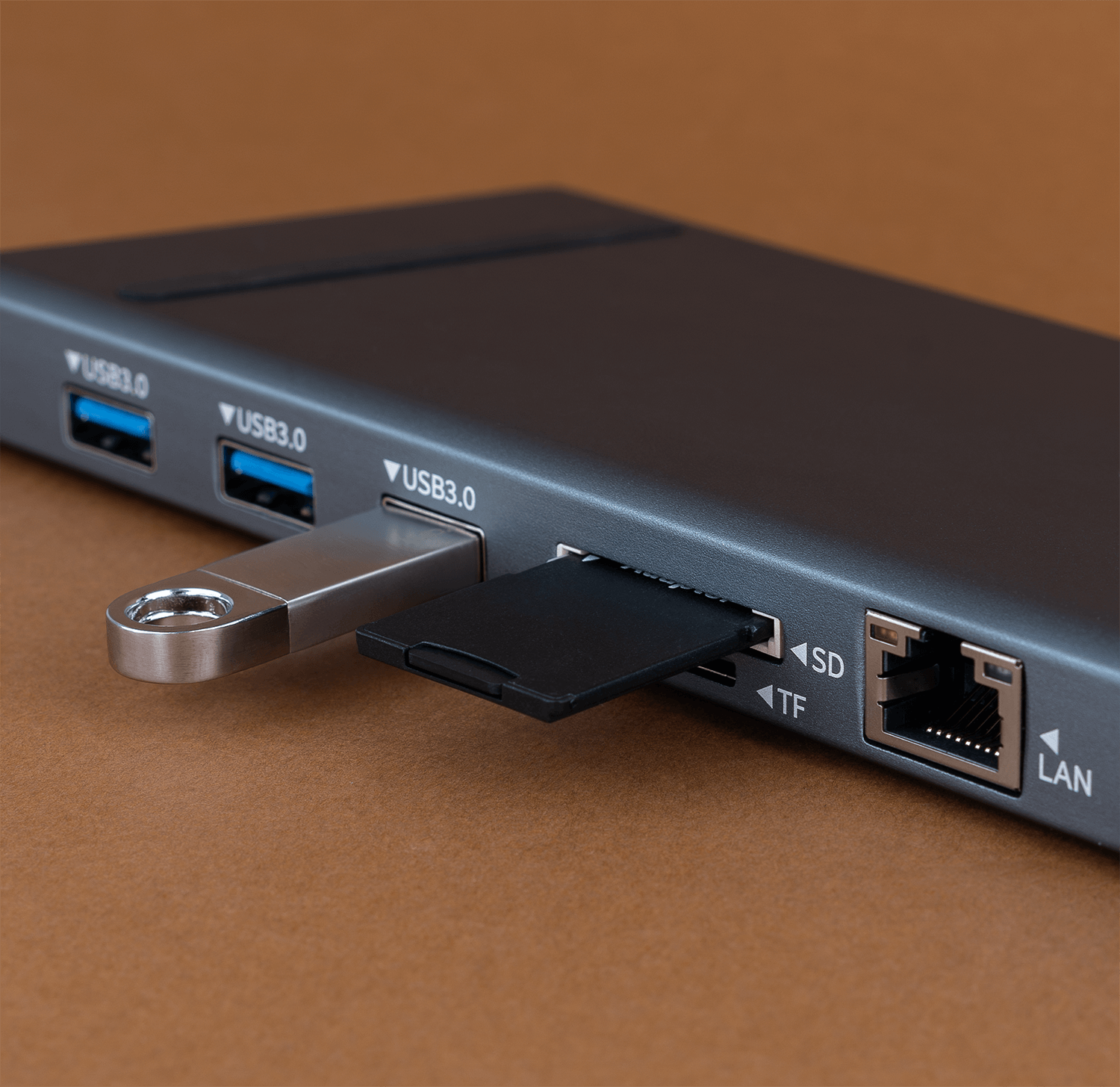 Zbliżenie szarego koncentratora z portami USB i kart SD oraz dyskiem USB.