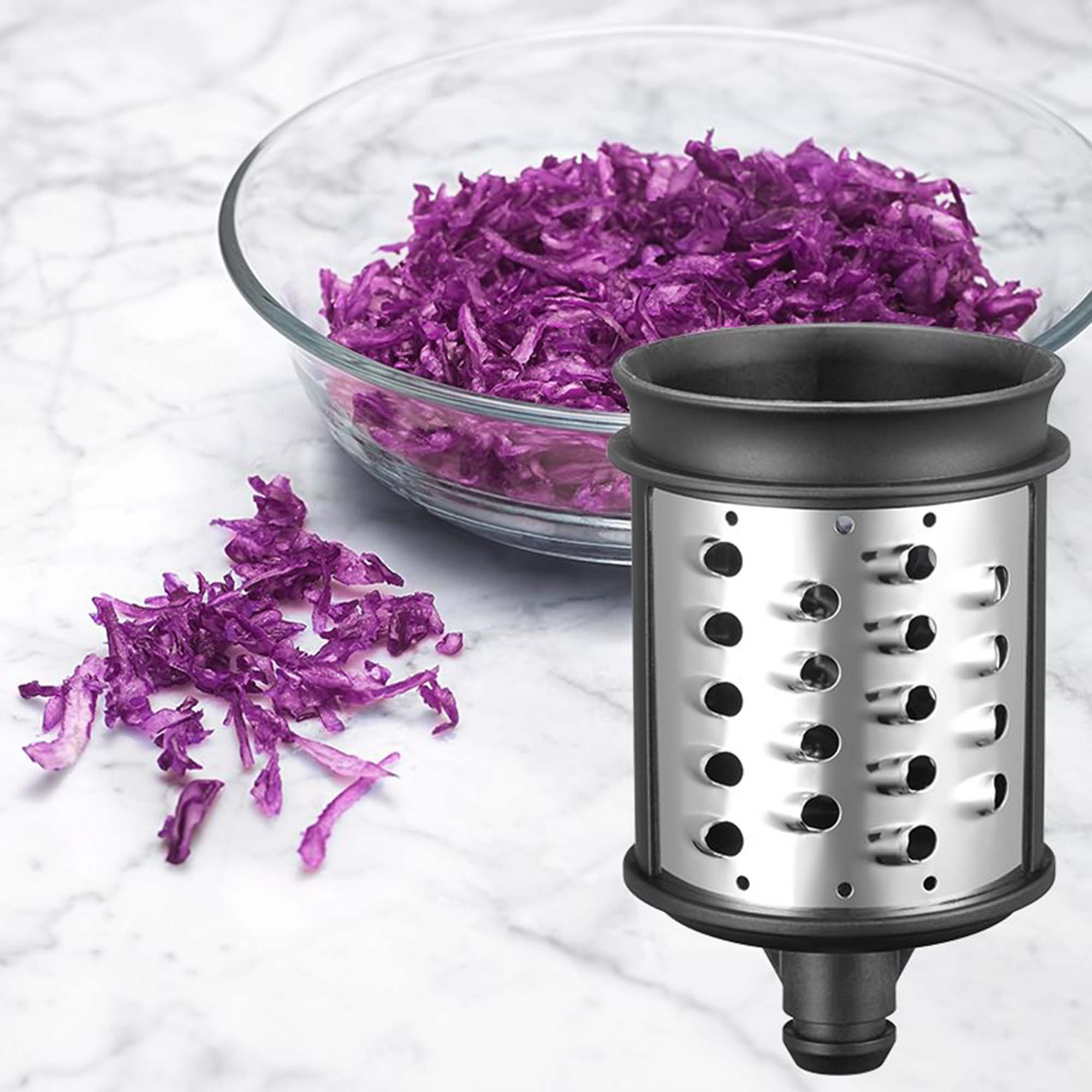 Eine Reibe mit zerkleinertem Rotkohl in einer Schüssel und lose auf der Oberfläche.