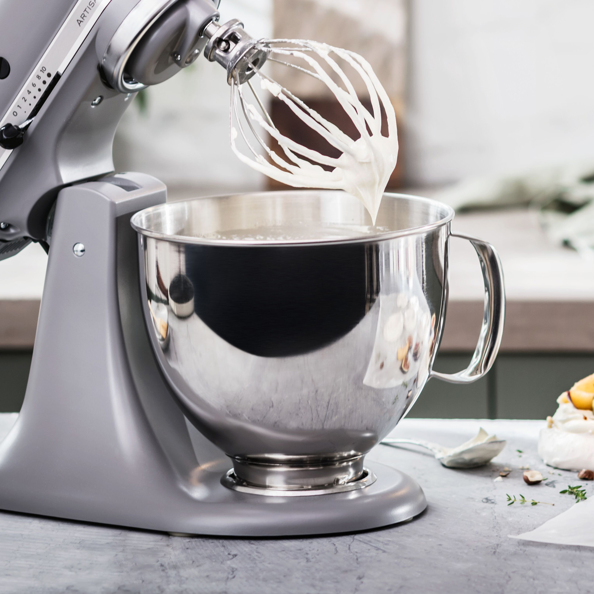 Grauer KitchenAid-Mixer mit Schlagsahne in einer Schüssel.