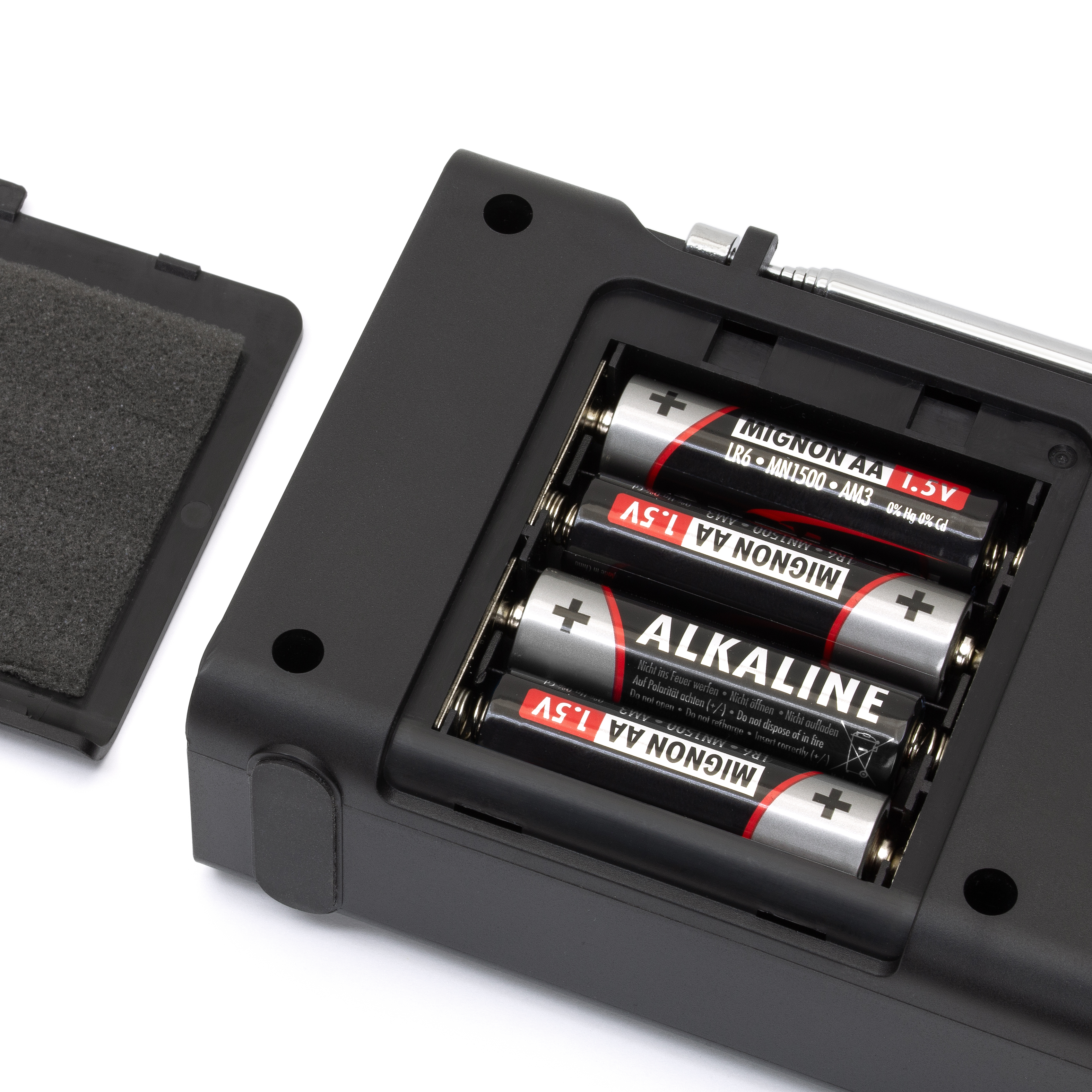Geöffnetes Batteriefach eines Radios, mit Batterien darin.