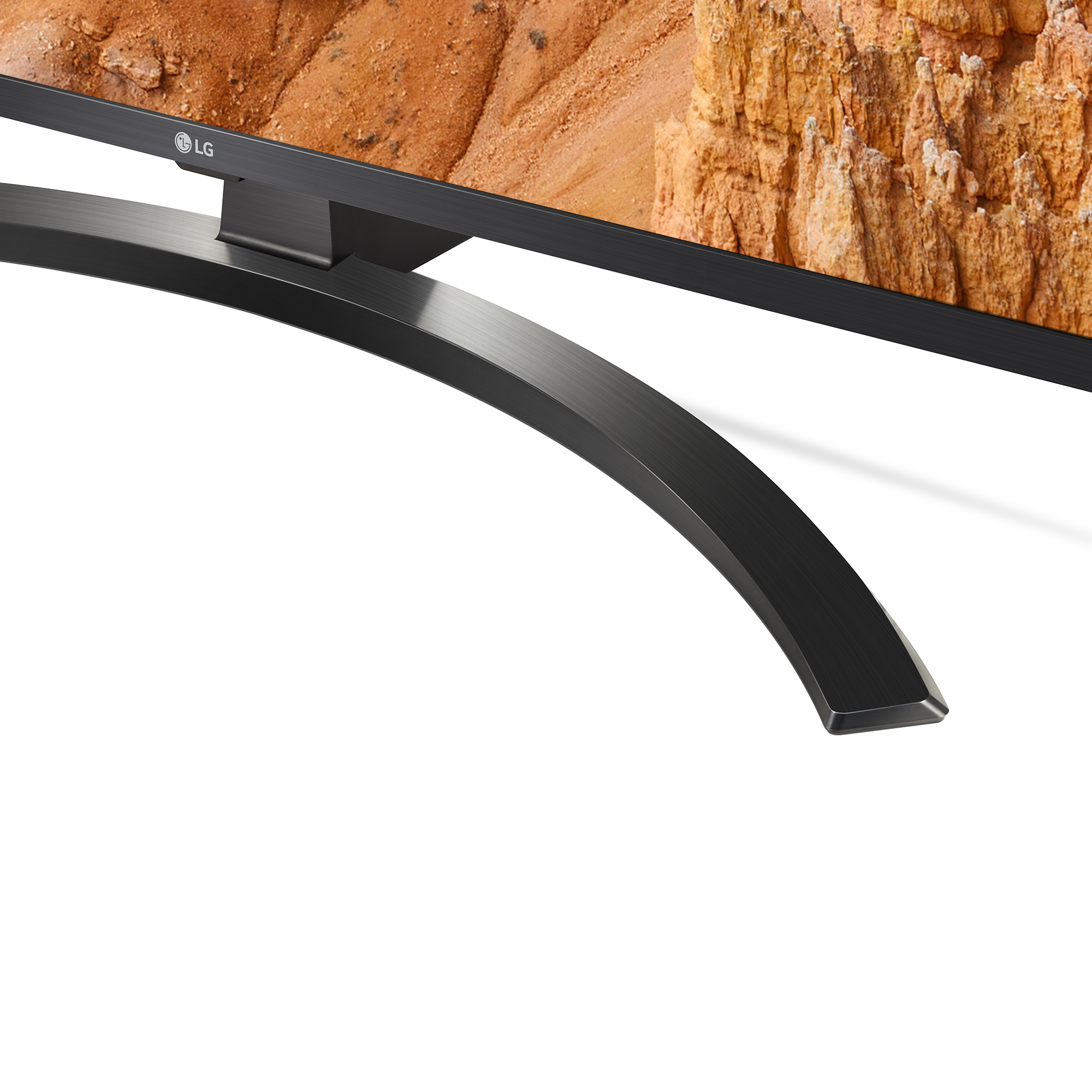 Primo piano di un supporto TV nero dal design curvo, che sostiene un televisore con un'immagine di paesaggio.