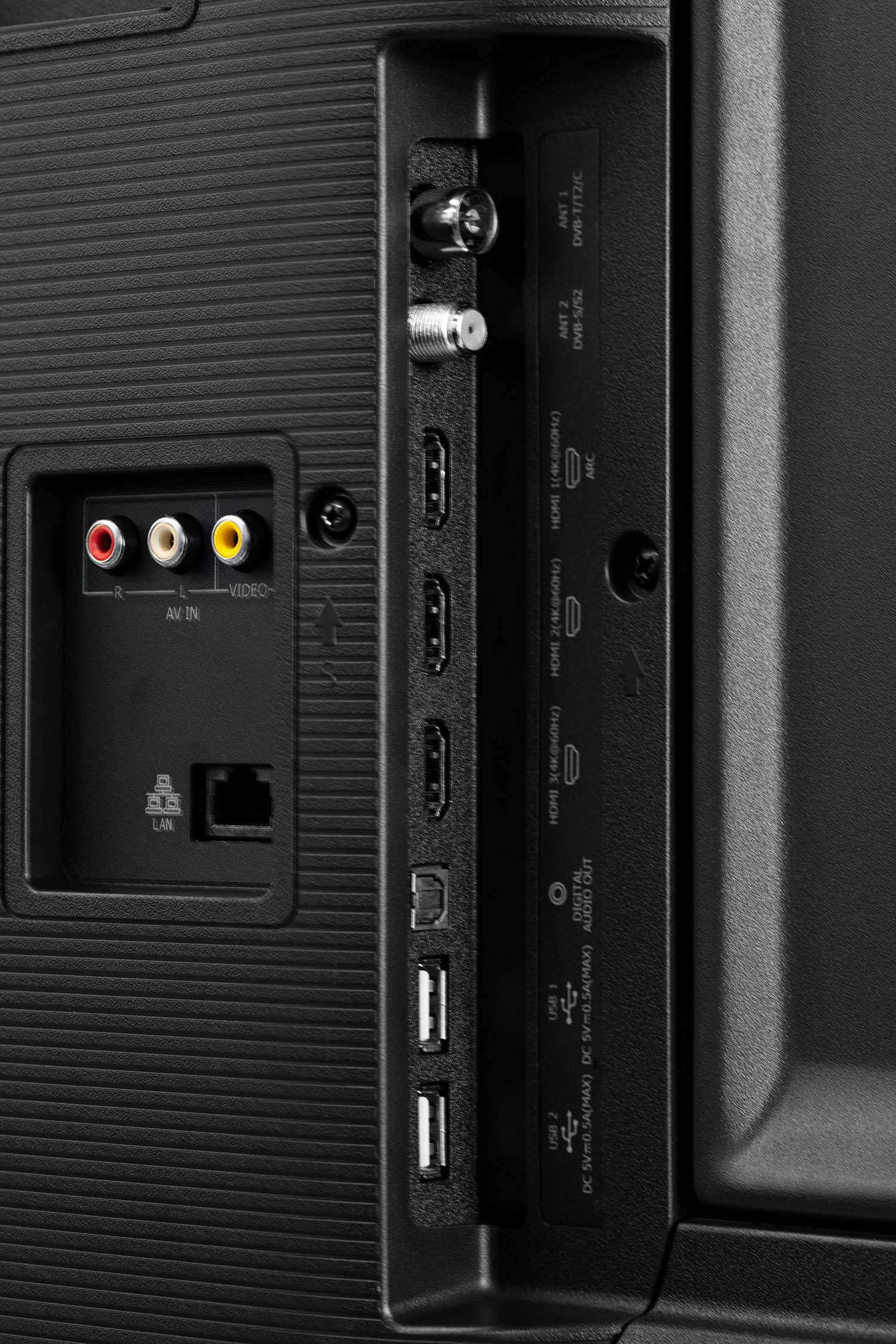 Zbliżenie portów TV z tyłu. Zawiera AV IN, LAN, HDMI, USB i połączenia antenowe. Czarny plastik.