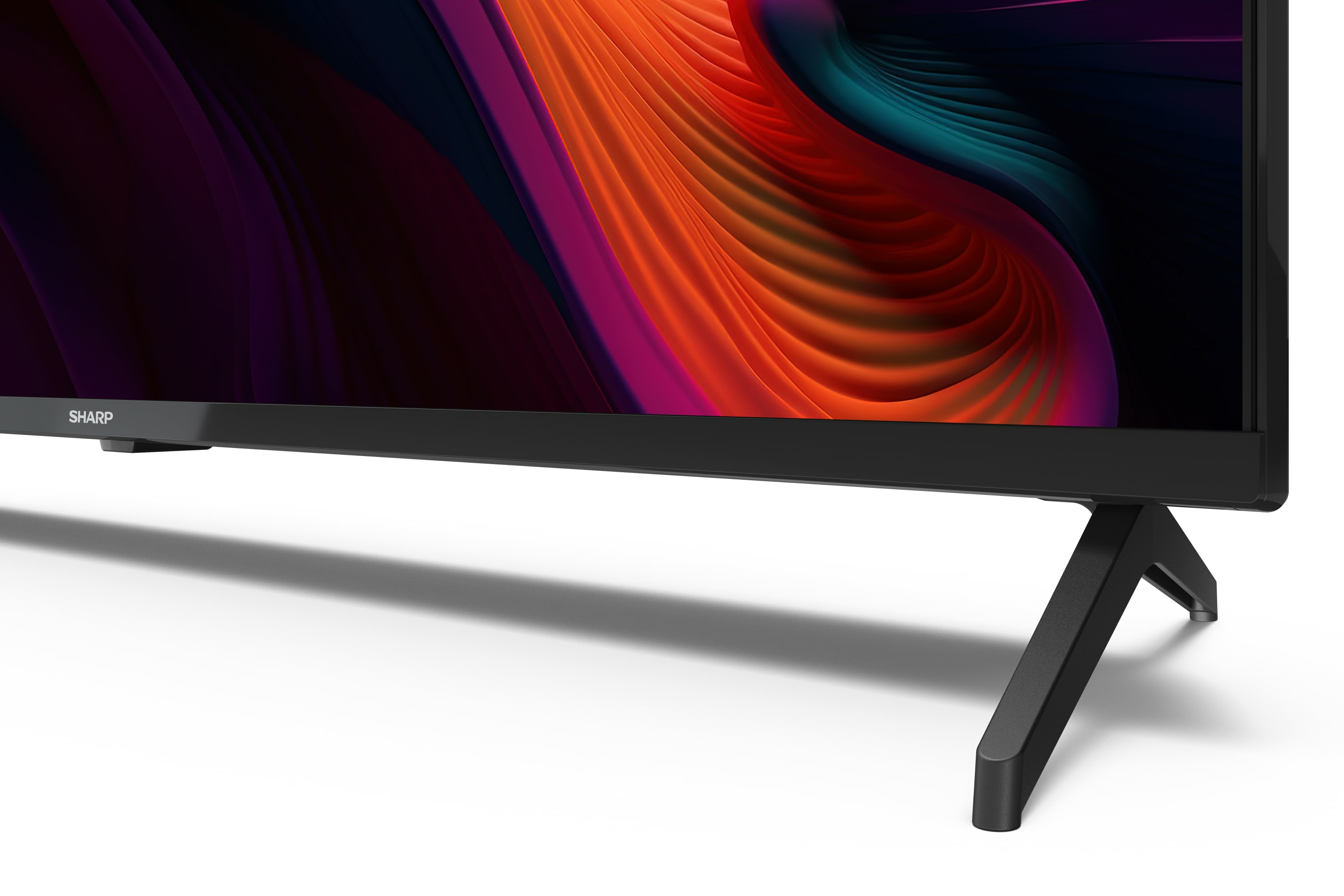 A Sharp TV with a black frame and legs, displayed on a white surface.