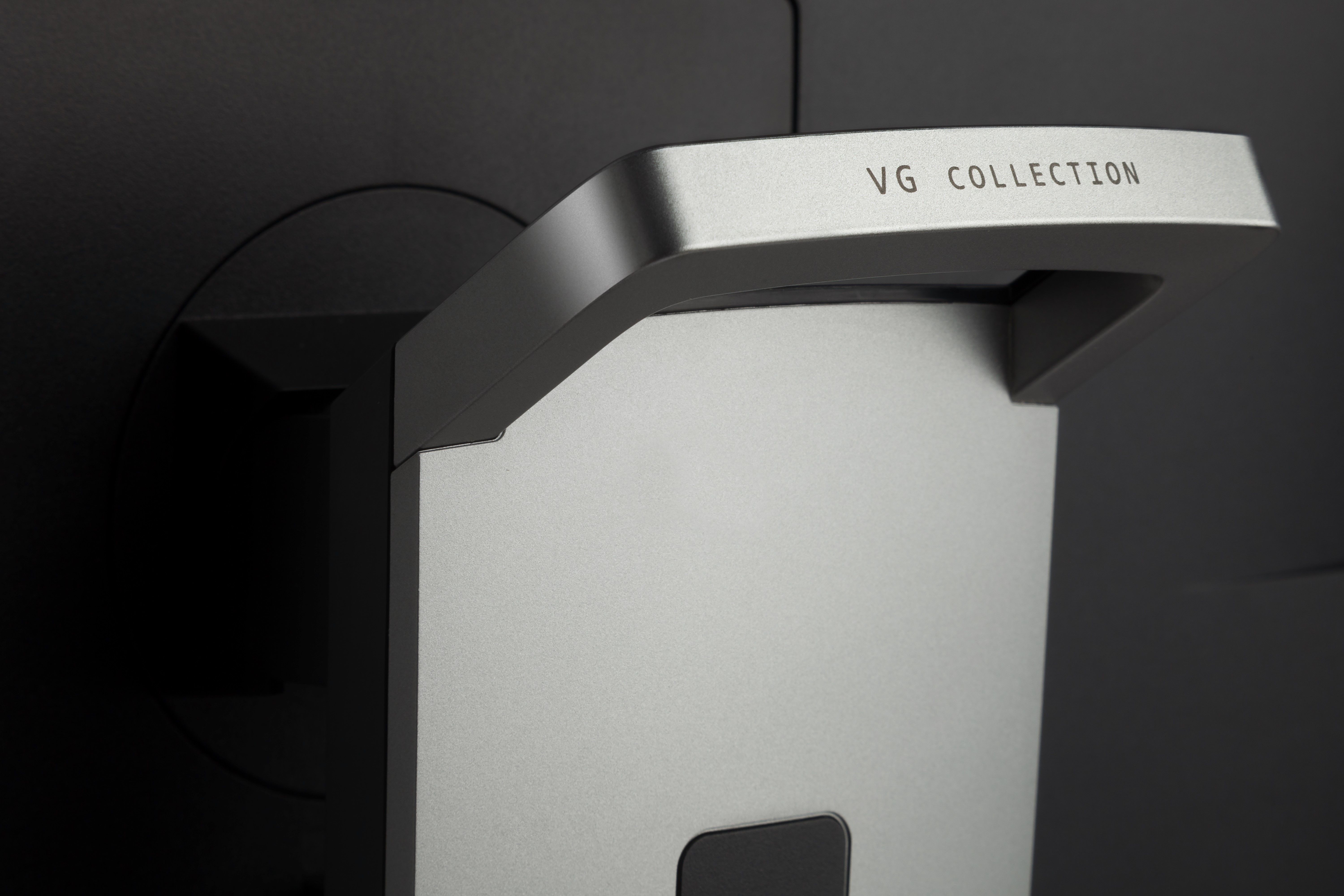 Bir monitörün desteğinin yakın çekimi, "VG COLLECTION" metniyle.