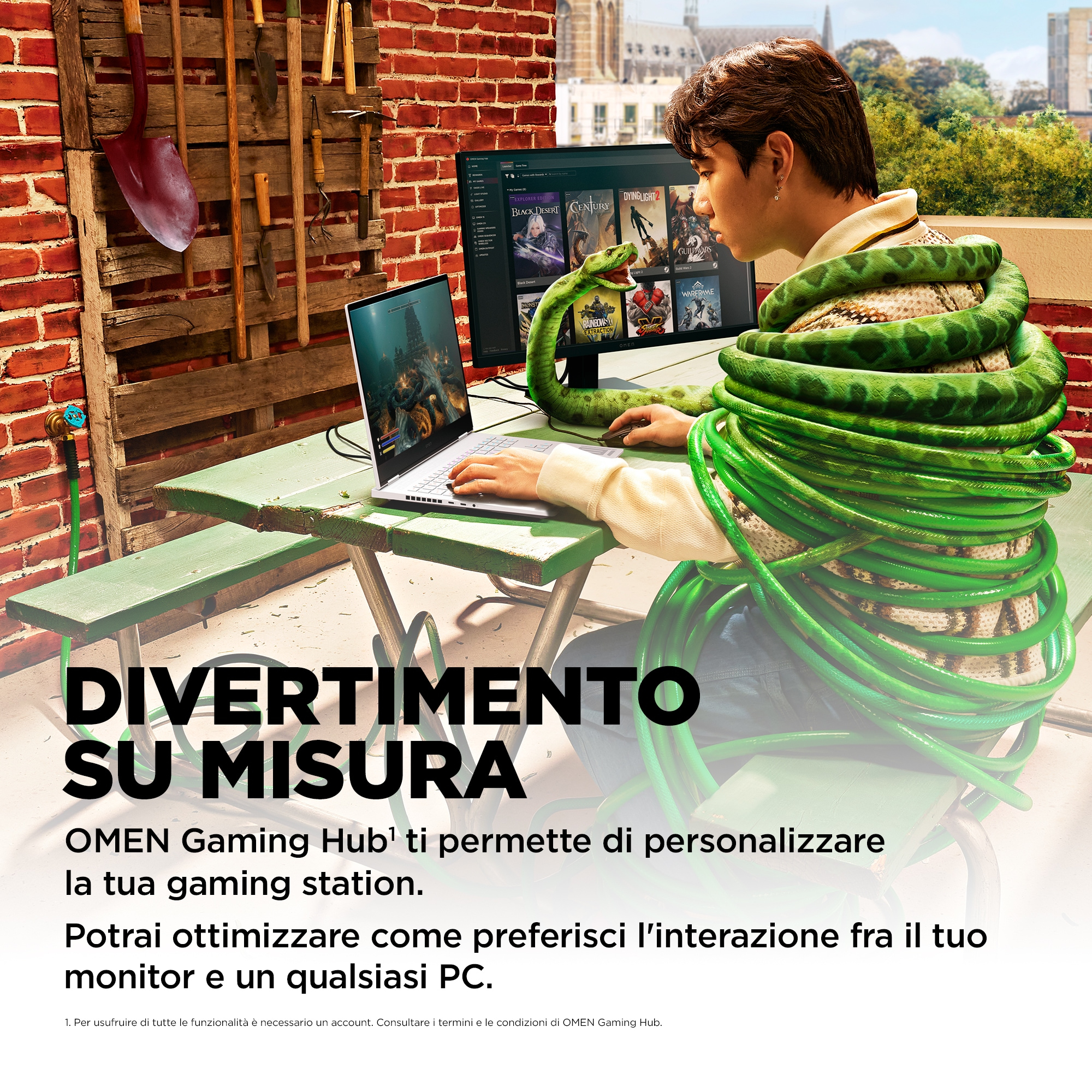 Mężczyzna siedzi przy stole przed monitorem i laptopem, z zielonym wężem.