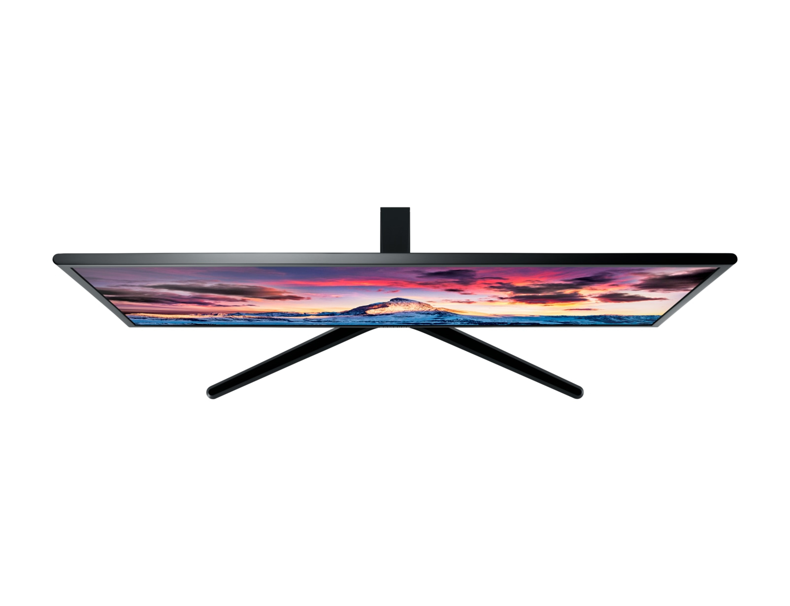 Monitor visto dall'alto, mostra un tramonto colorato con una montagna.