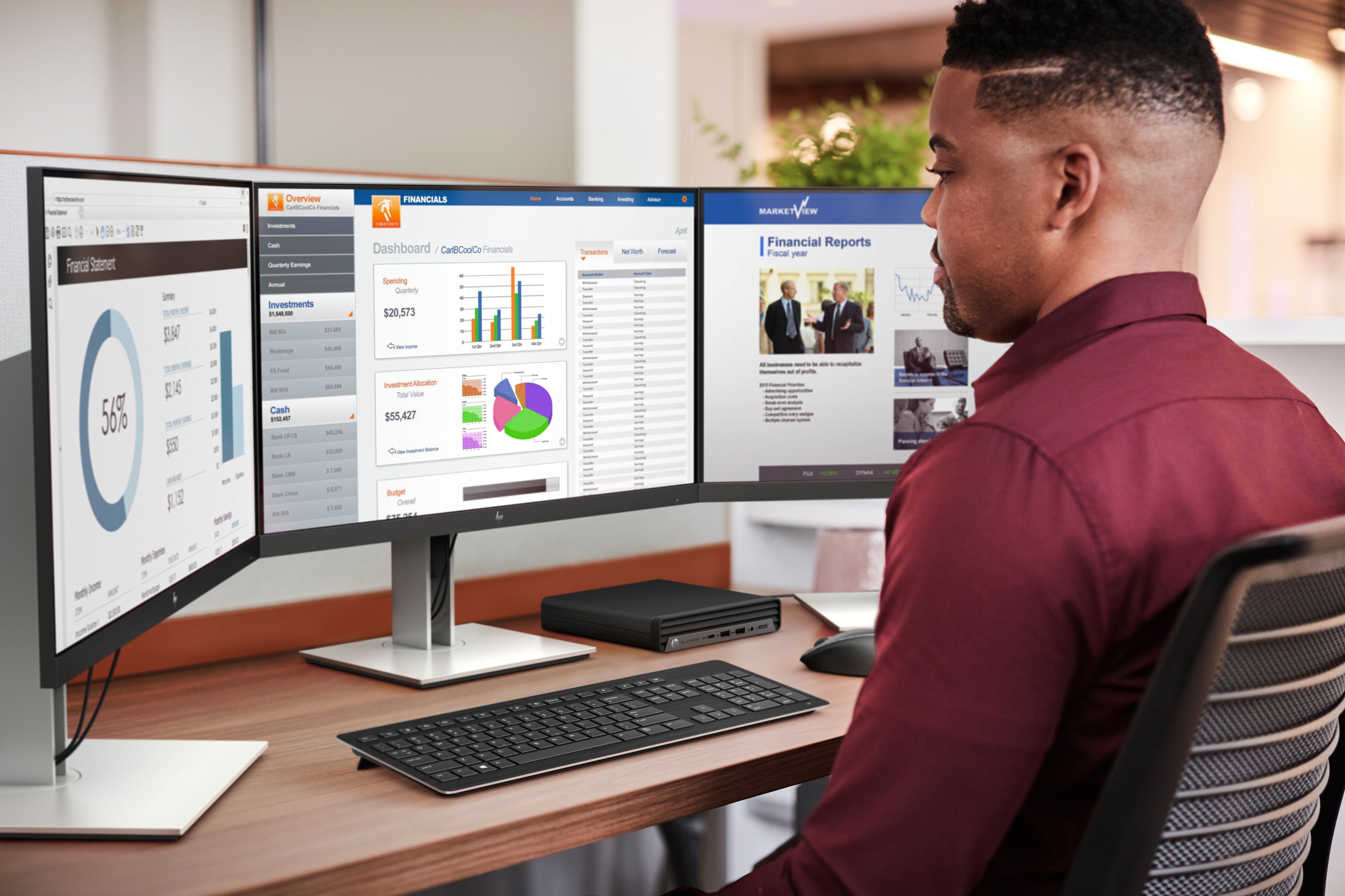 Mężczyzna używający trzech monitorów przy biurku. Ekrany pokazują wykresy i dane finansowe. Klawiatura i mysz obecne.