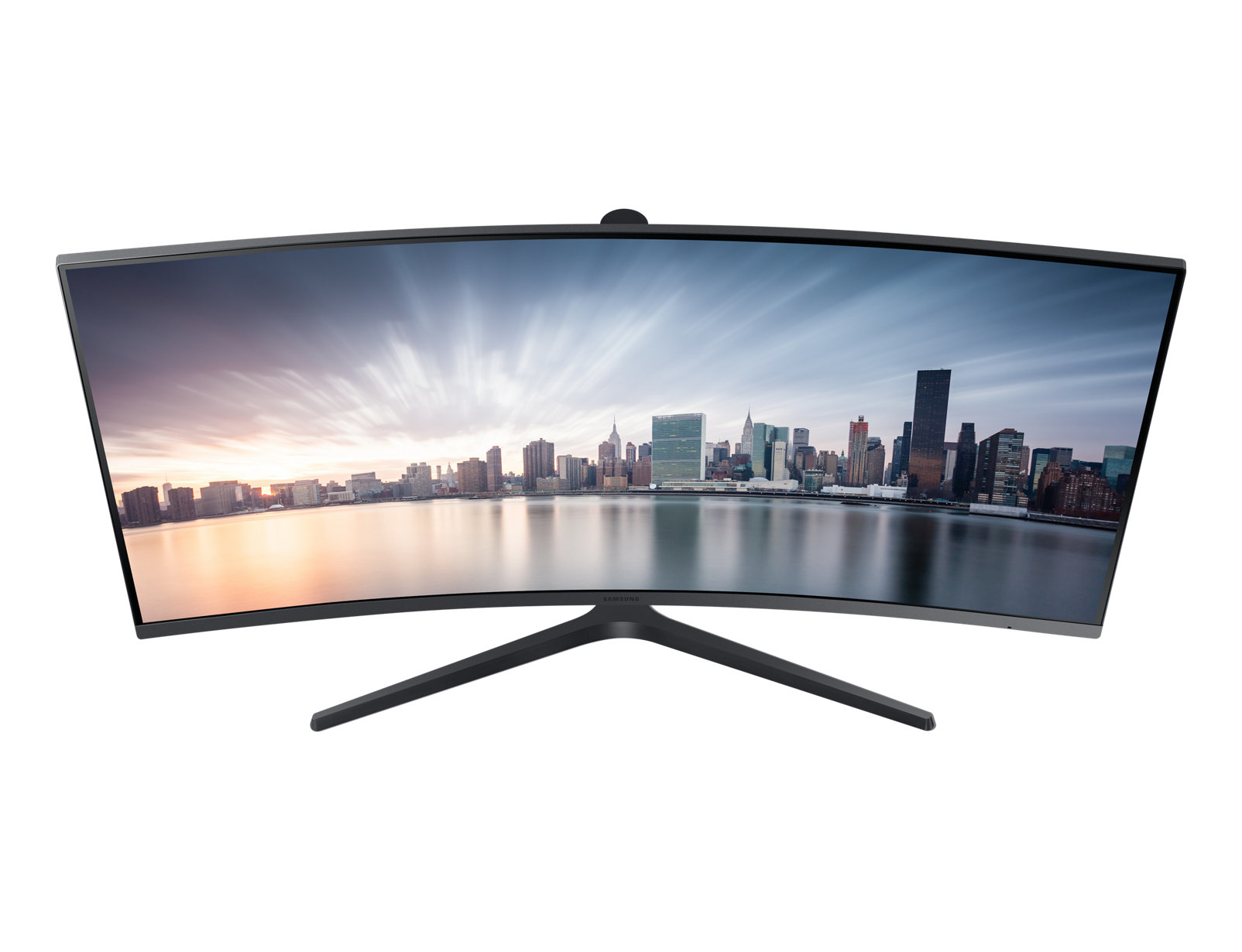 Un monitor Samsung curvo muestra un paisaje urbano sobre agua con colores de atardecer. El soporte es negro.