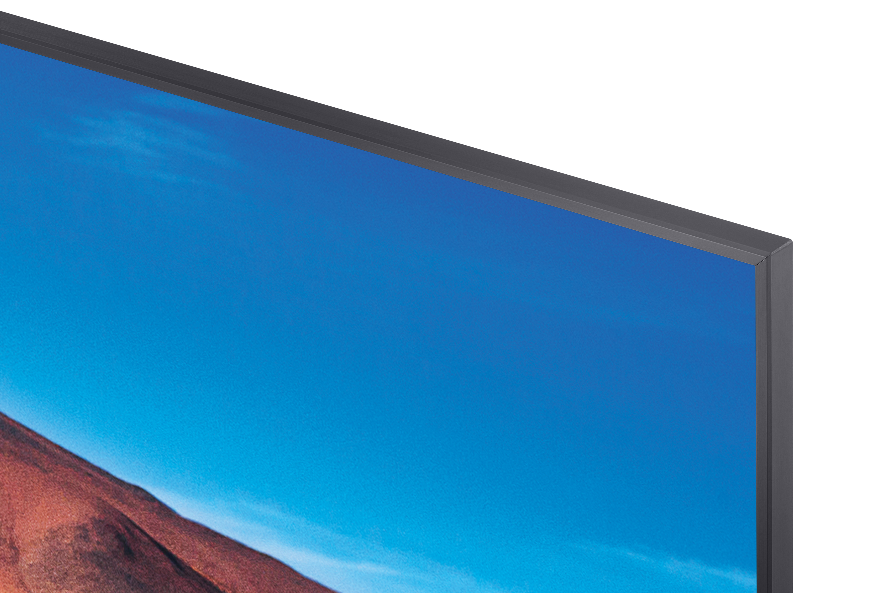 Róg monitora z błękitnym niebem i czerwonymi górami na wyświetlaczu.