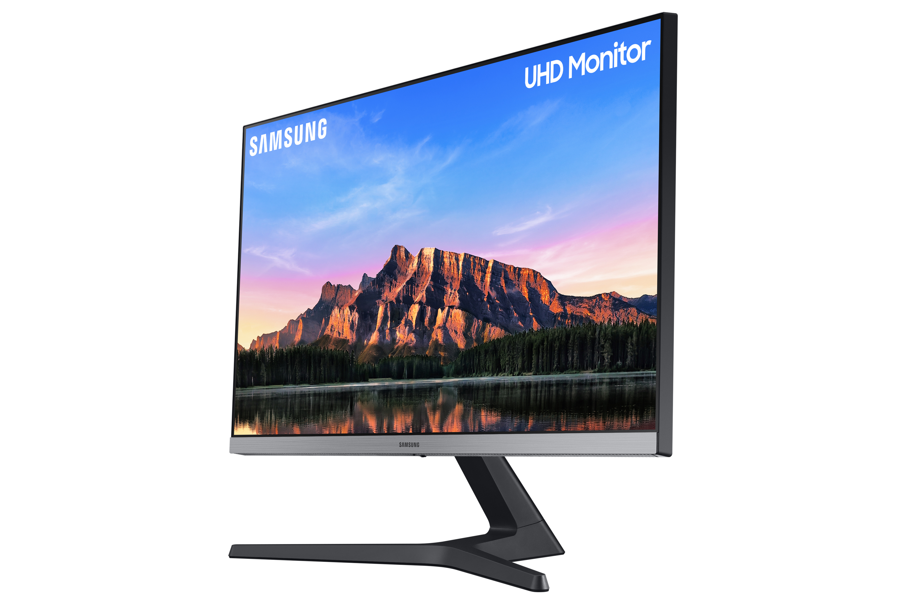 Monitor Samsung con imagen de paisaje. La pantalla tiene cielo azul, montañas y agua.