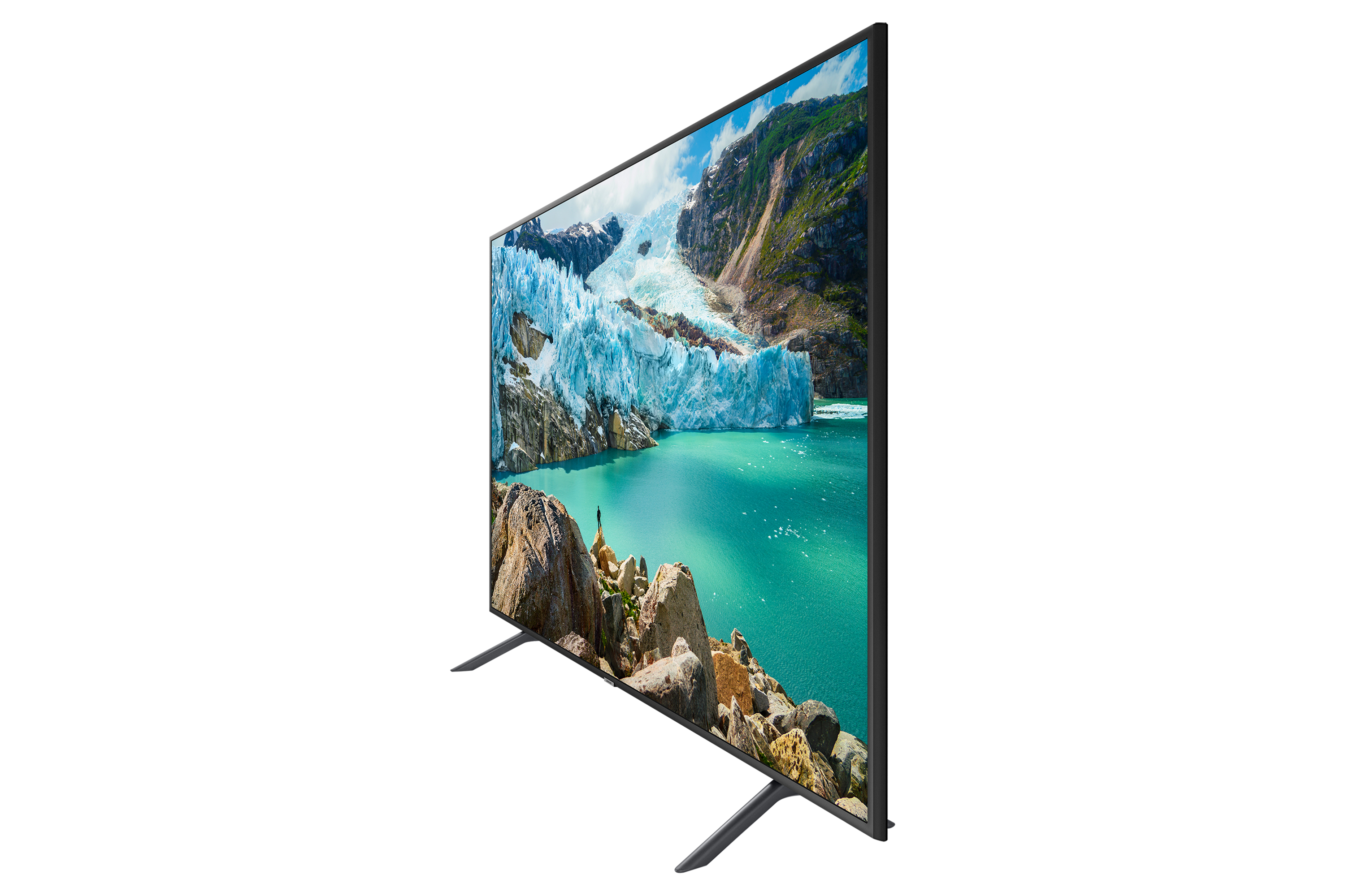 Una TV mostra un paesaggio di montagne e acqua. È su due gambe. Lo schermo è nero.