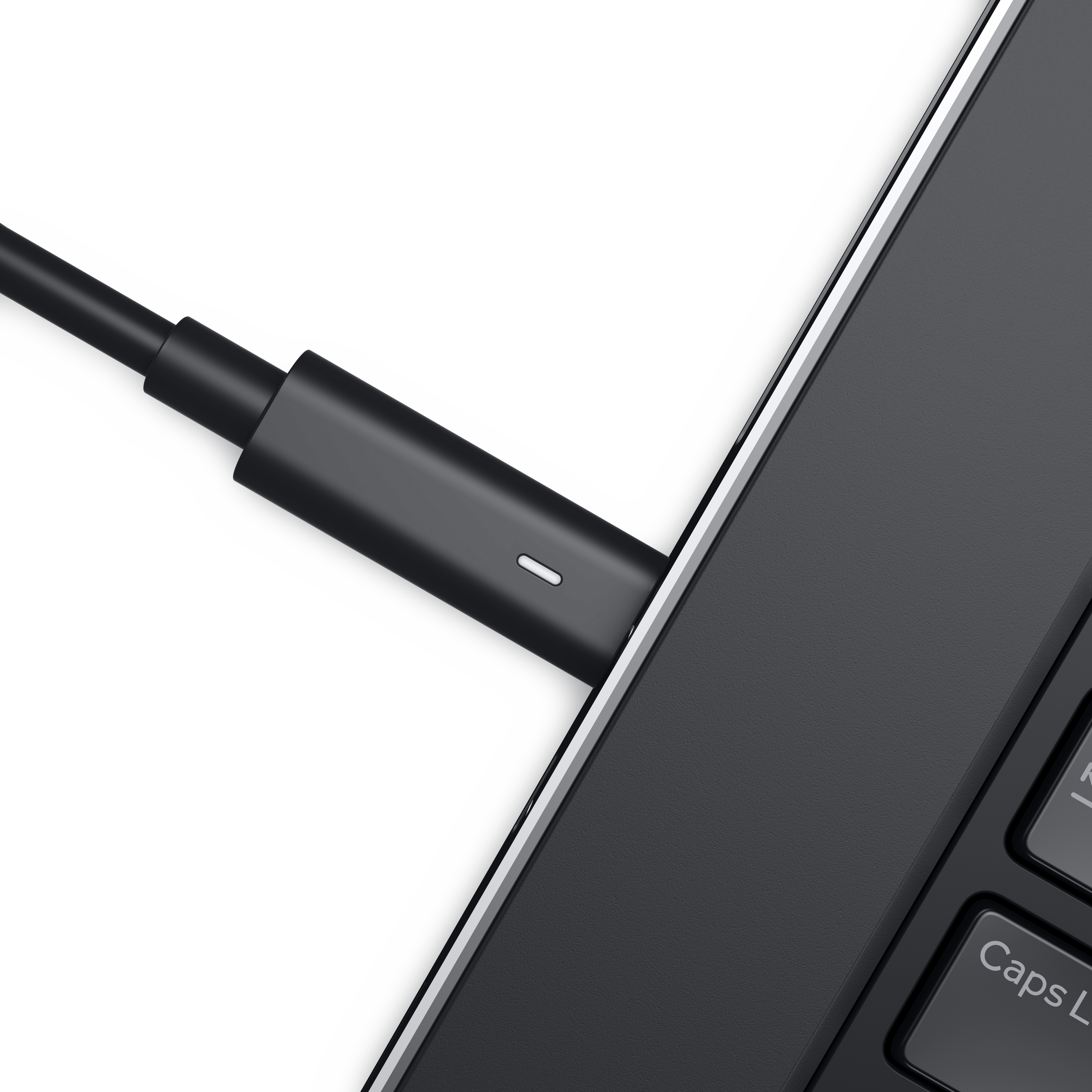 Ein schwarzes Ladekabel ist an einen Laptop angeschlossen, Nahaufnahme, zeigt den Stecker und die Tastatur.