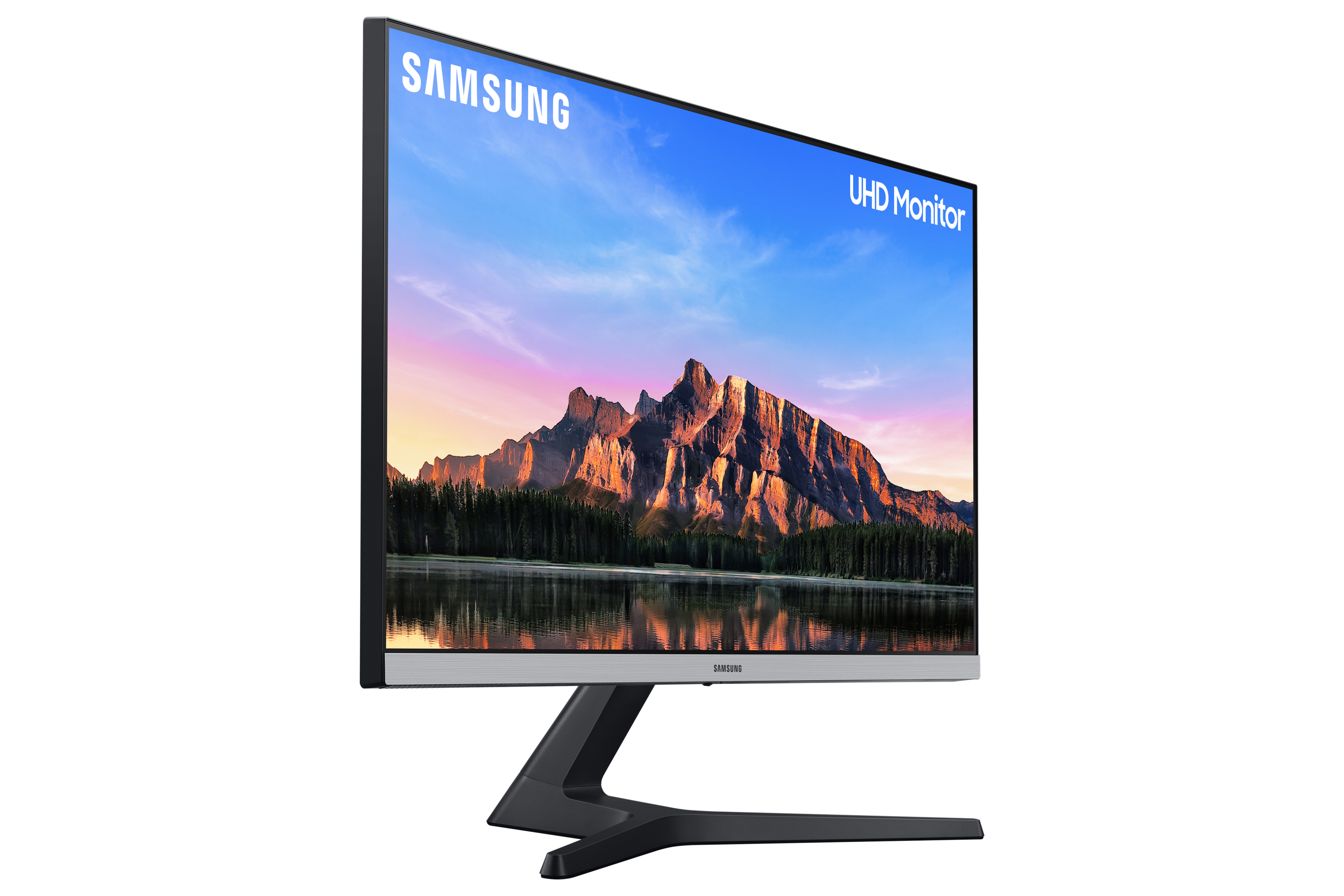 Un monitor SAMSUNG UHD mostrando un paisaje con montañas, agua y un cielo colorido.