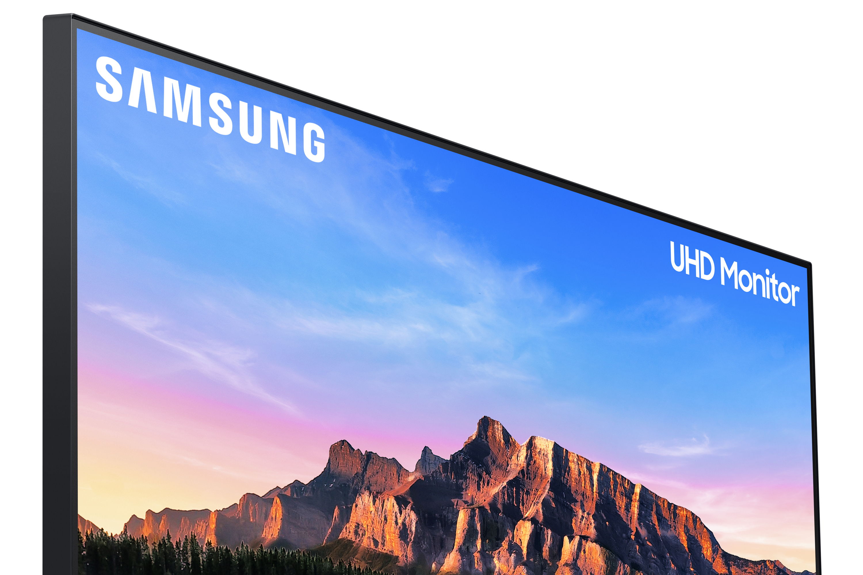 Primer plano de un monitor Samsung UHD que muestra un cielo azul y montañas.