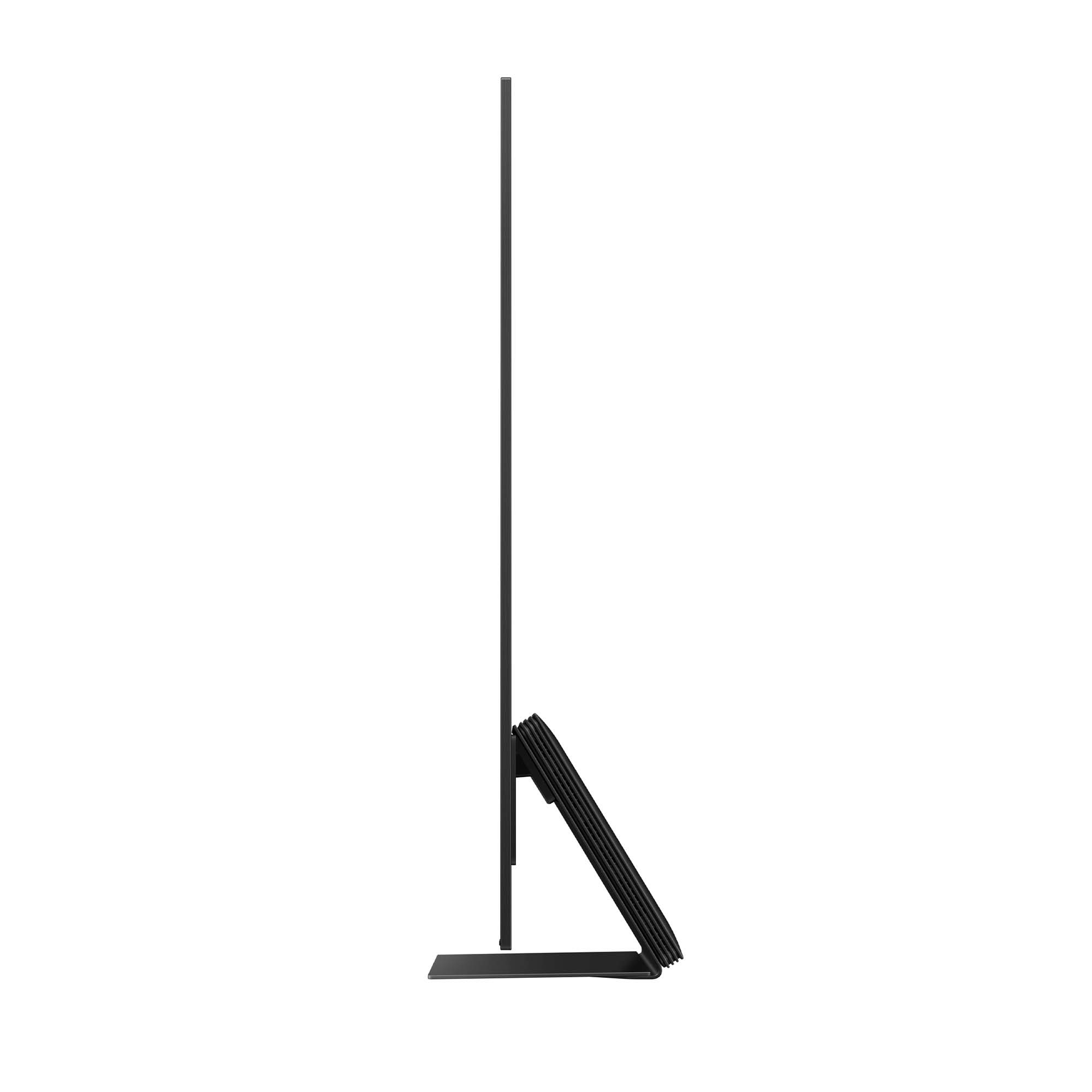 Smukły, czarny telewizor widziany z boku. Podstawa jest czarna. Ekran skierowany w lewo.