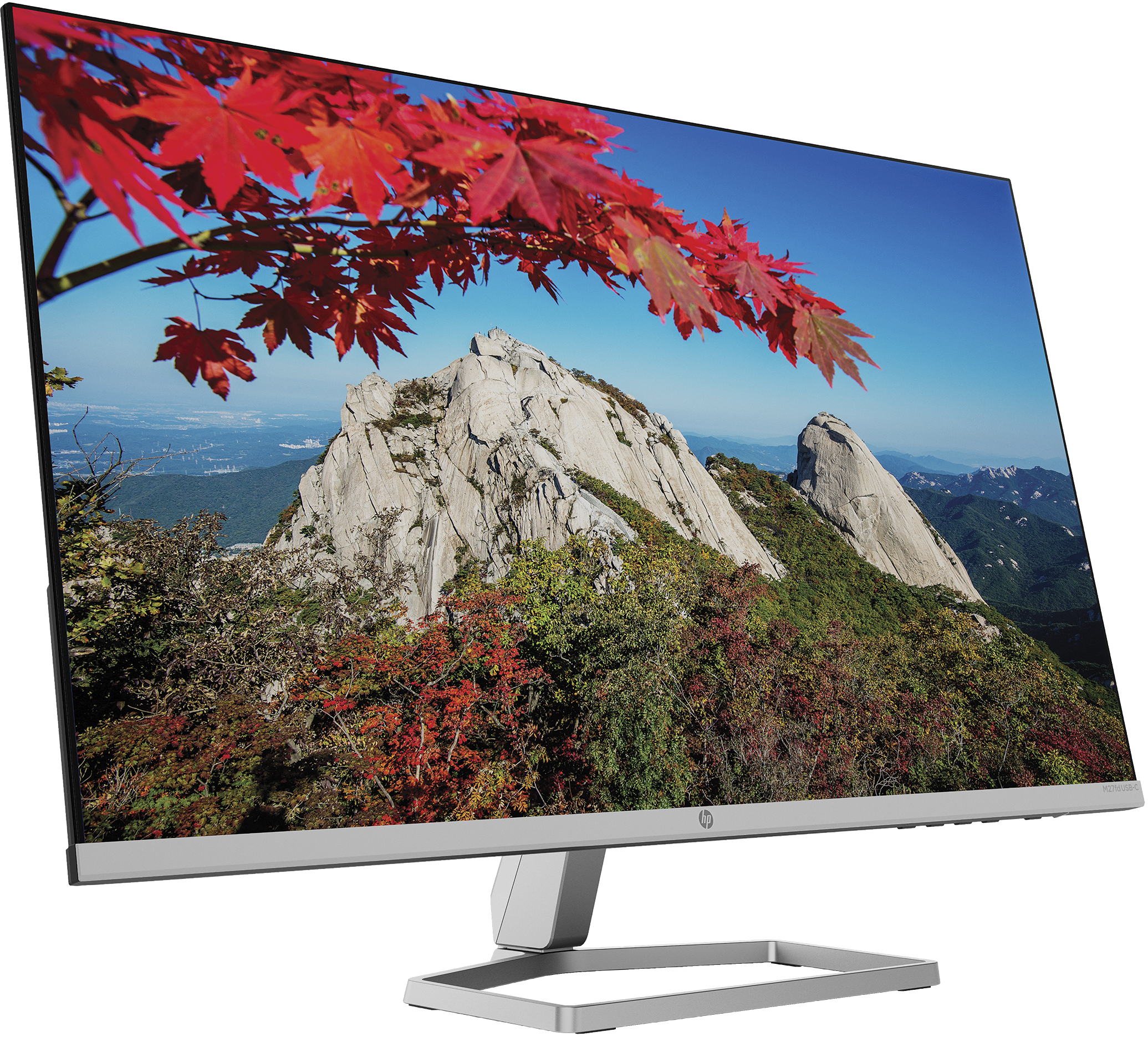 Un monitor HP mostra un paesaggio montano con fogliame autunnale e cielo blu.