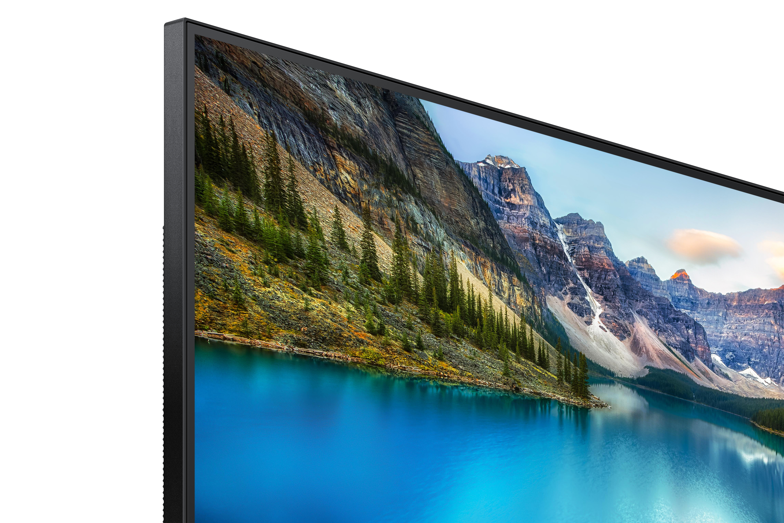 Primer plano de un monitor que muestra un paisaje con un lago y montañas.