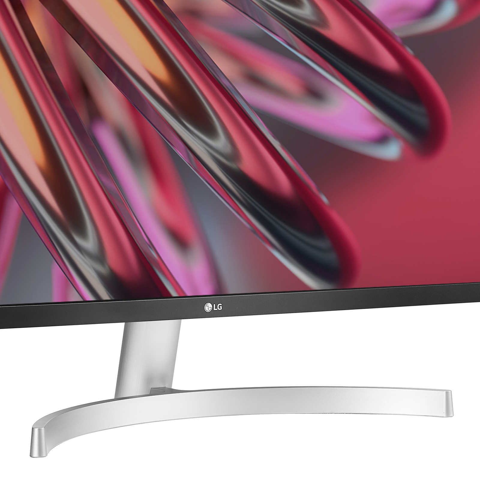 Un monitor LG con schermo curvo e supporto argentato. Lo sfondo mostra forme astratte rosse e rosa.