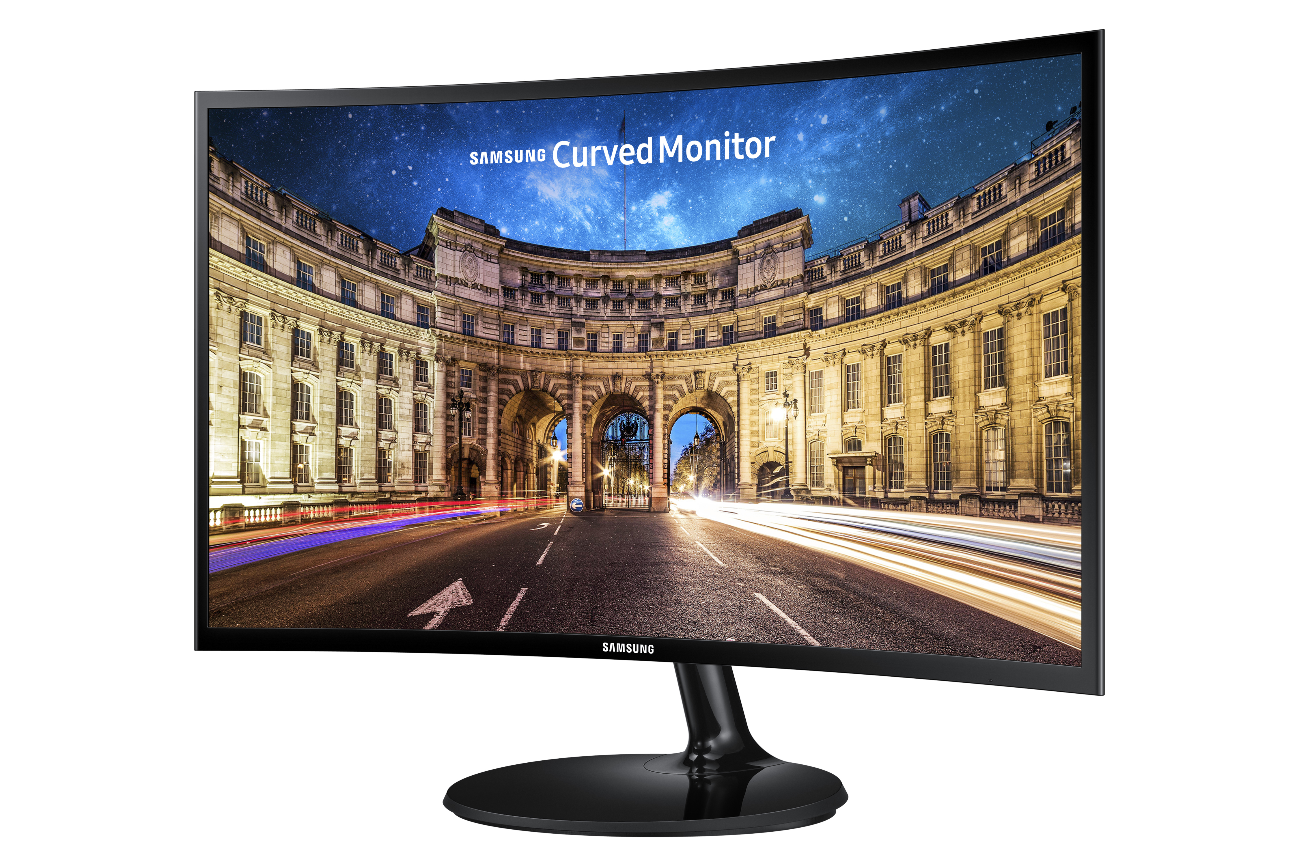 Monitor curvo Samsung mostra una strada cittadina notturna con luci e un edificio.