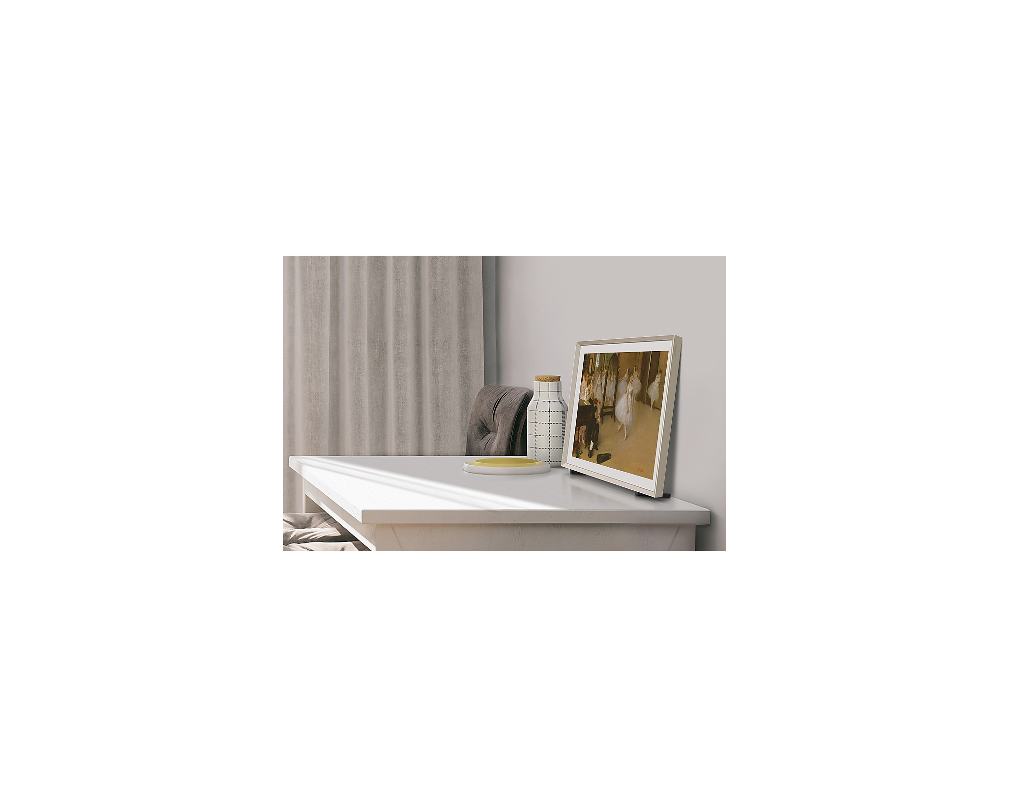 Obraz w ramie na białym stole, z butelką i talerzem obok.