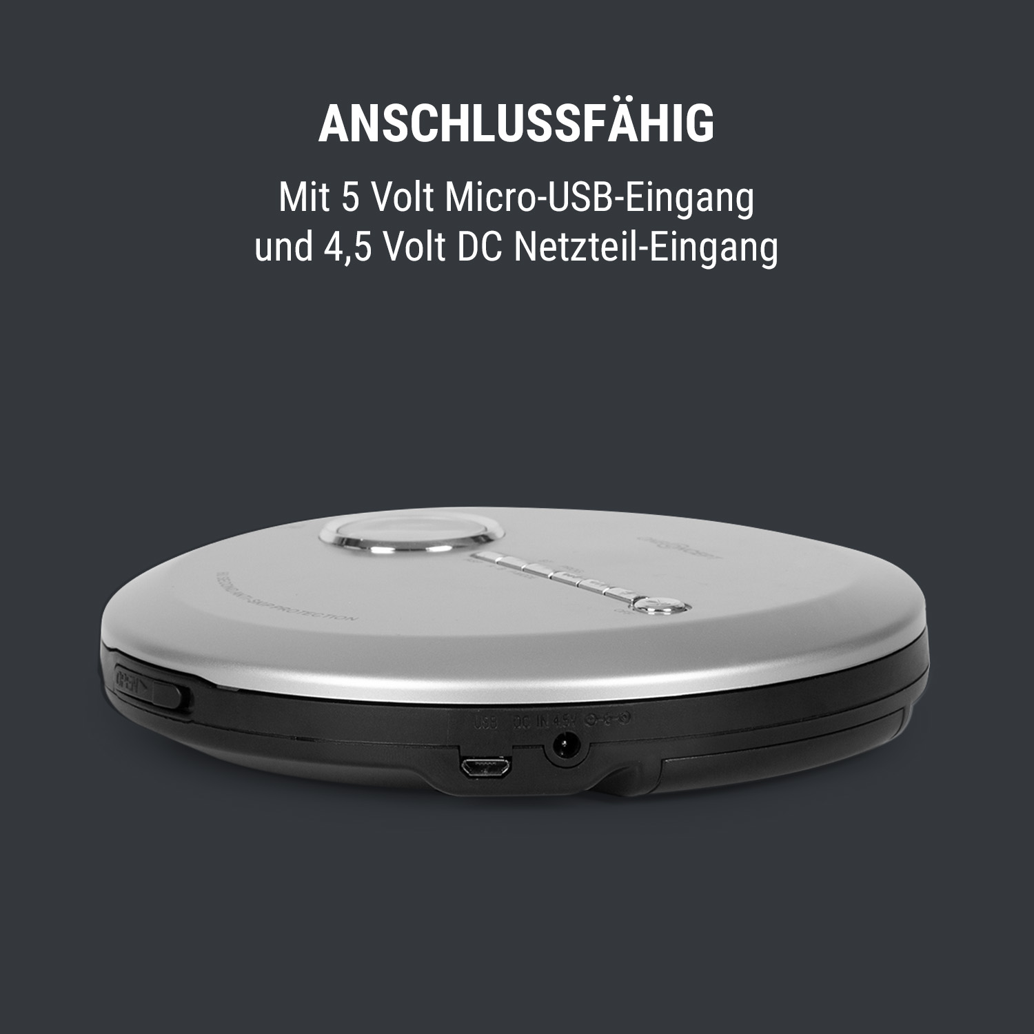 Silbernes Gerät mit USB- und Stromeingängen. Grauer Hintergrund. Text über Eingänge.