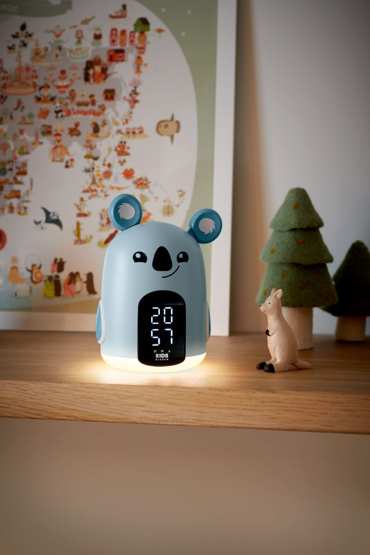 Koala-Uhr mit Digitalanzeige auf Holzregal, Kartenhintergrund.