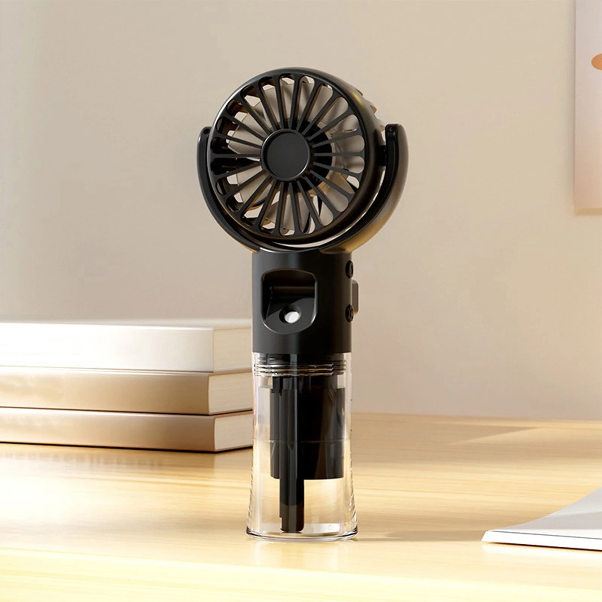 Ventilatore portatile nero con serbatoio dell'acqua e griglia. È su una scrivania.