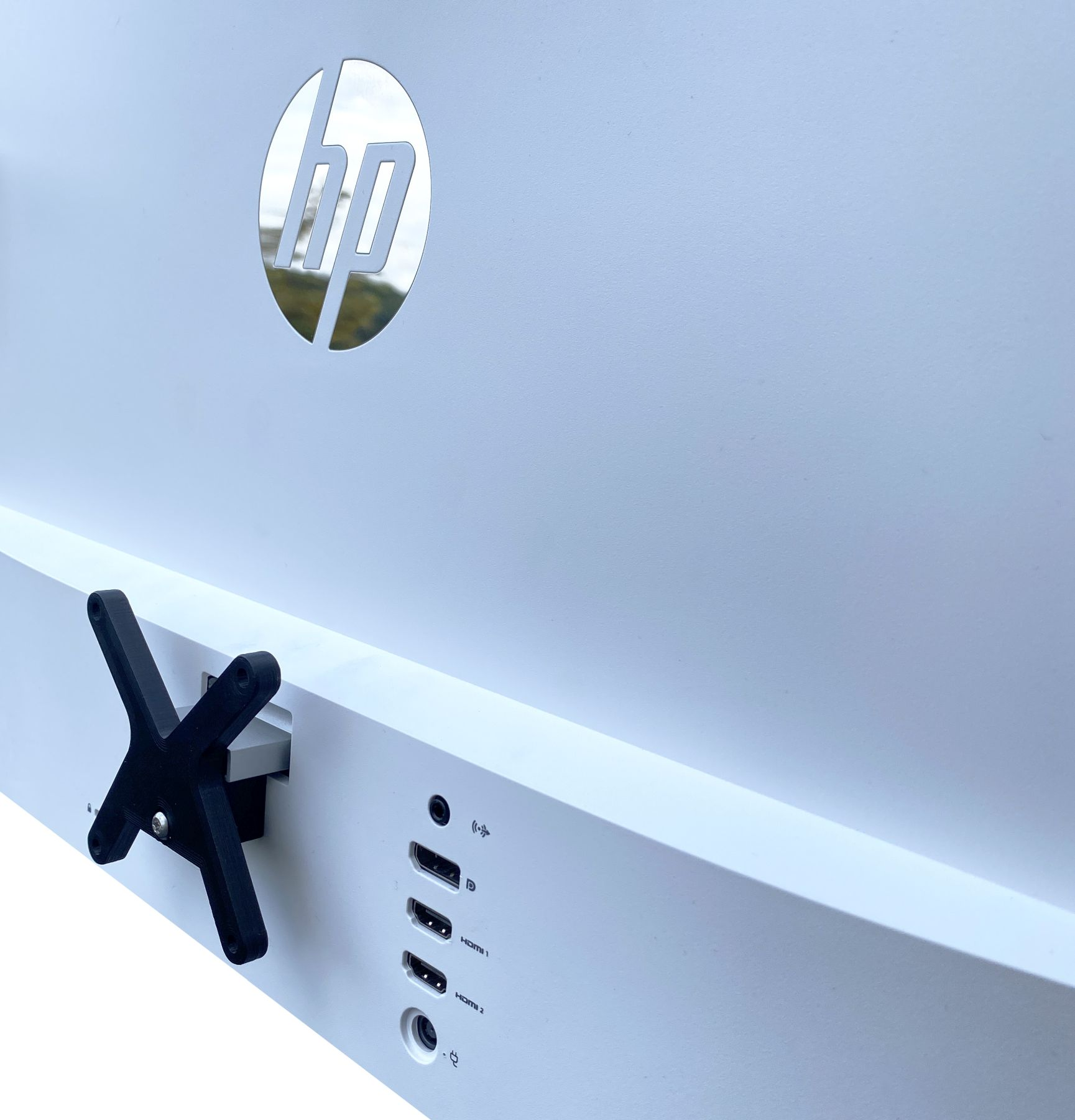 Rückseite eines weißen HP-Monitors mit schwarzer Halterung.