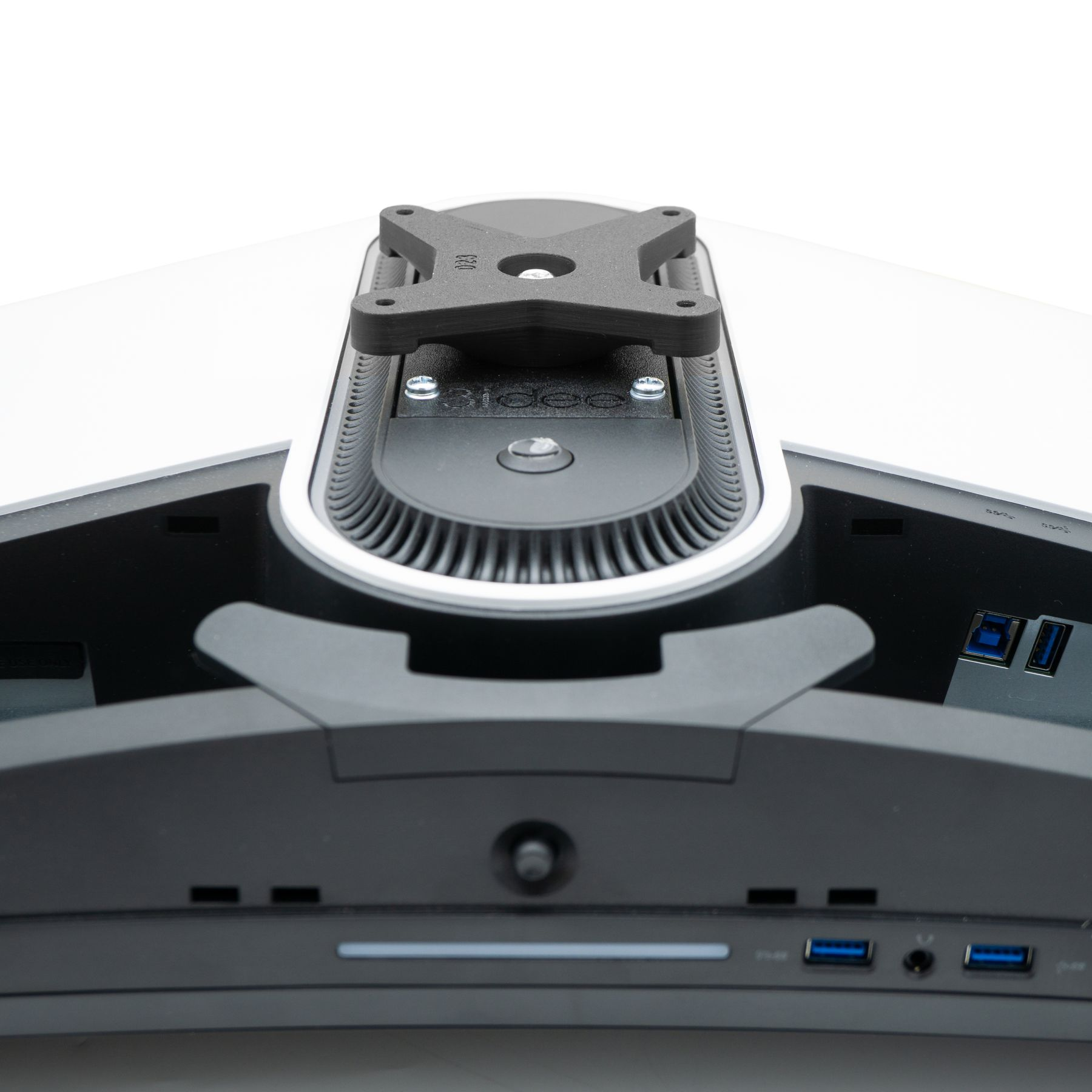 Nahaufnahme der Rückseite eines Computermonitors mit schwarzer Halterung und Schrauben.