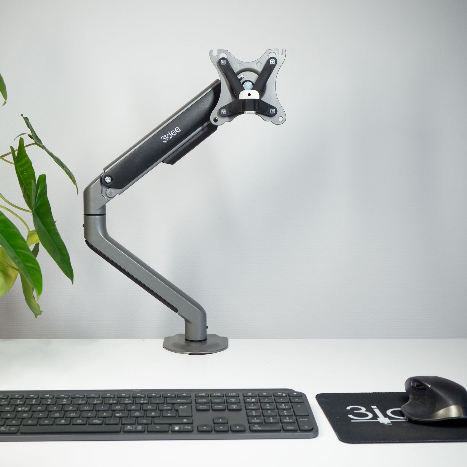 Monitorarm auf einem weißen Schreibtisch. Tastatur und Maus sind ebenfalls sichtbar.