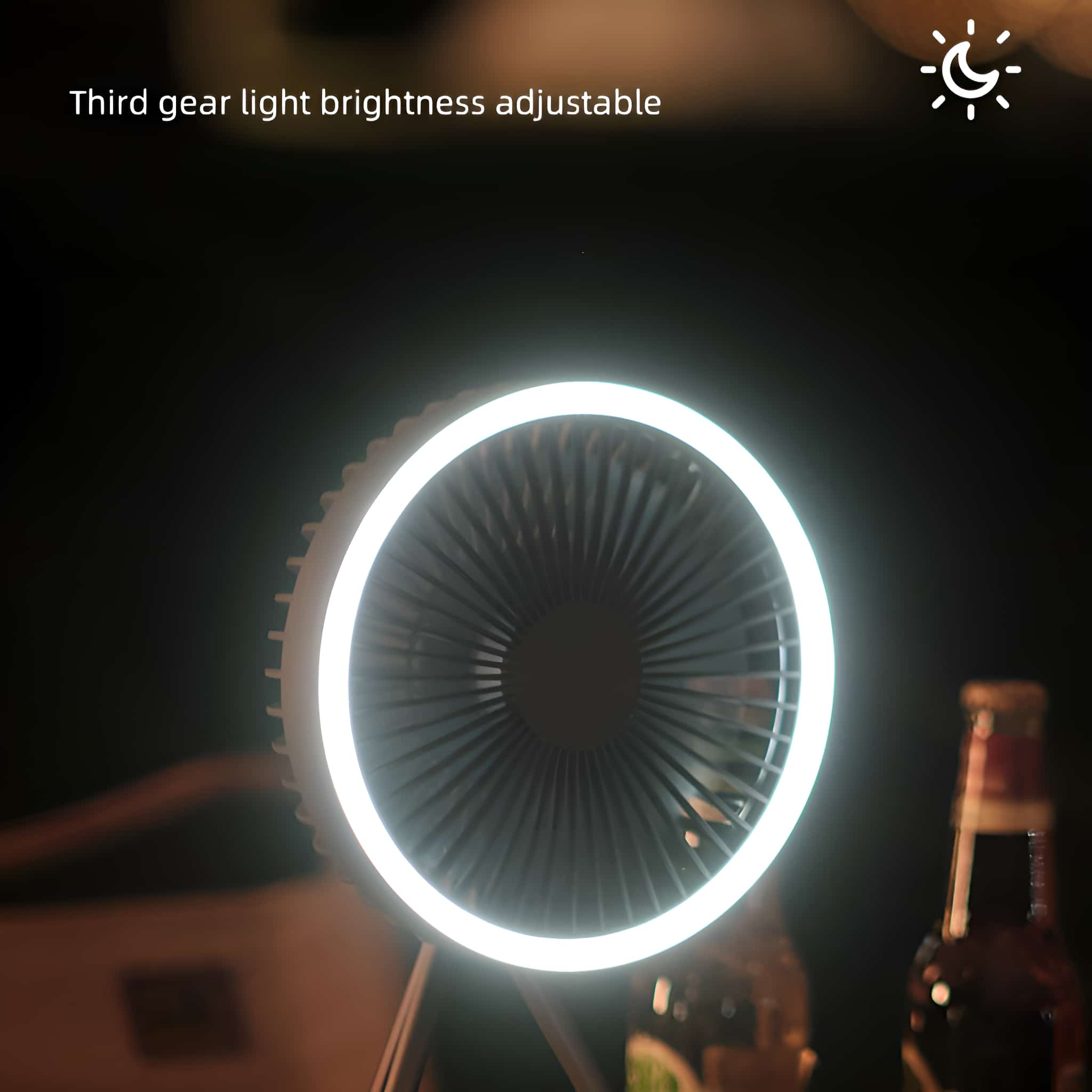 Ein tragbarer Ventilator mit einem Lichtring um die Rotorblätter, auf einem Ständer. Dunkler Hintergrund.