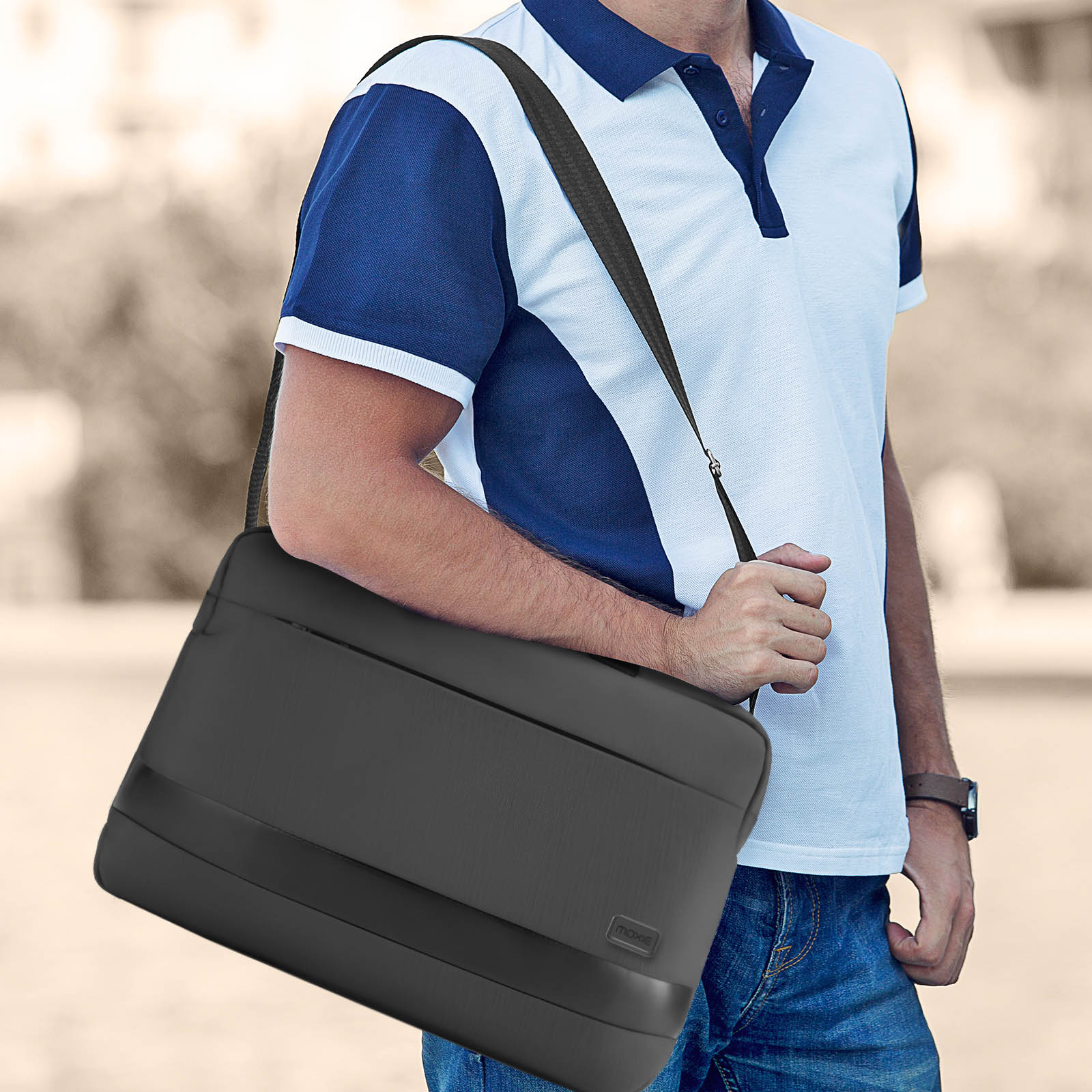 Mann mit weiß-blauem Poloshirt, trägt eine schwarze Umhängetasche.