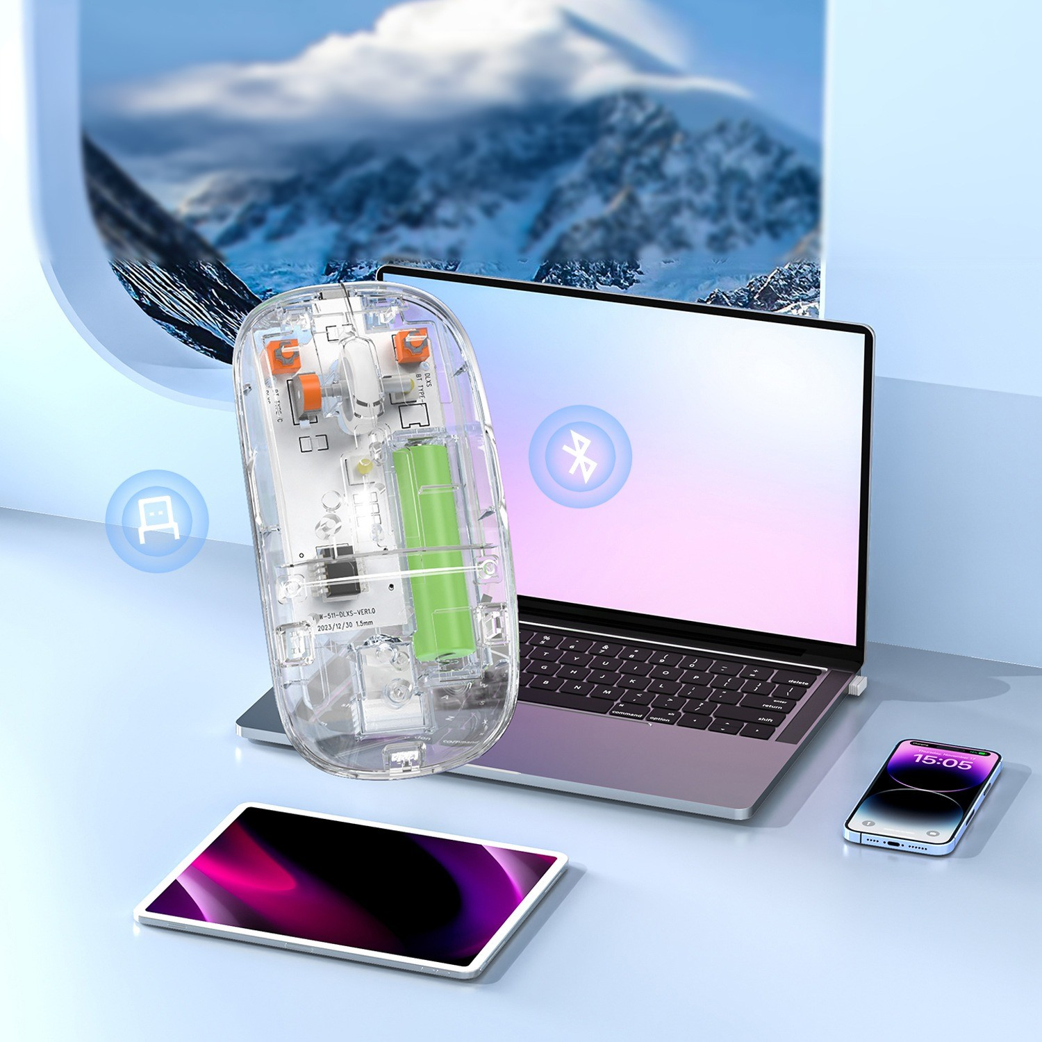 Eine transparente Computermaus neben einem Laptop, einem Tablet und einem Smartphone. Schneebedeckte Berge im Hintergrund.